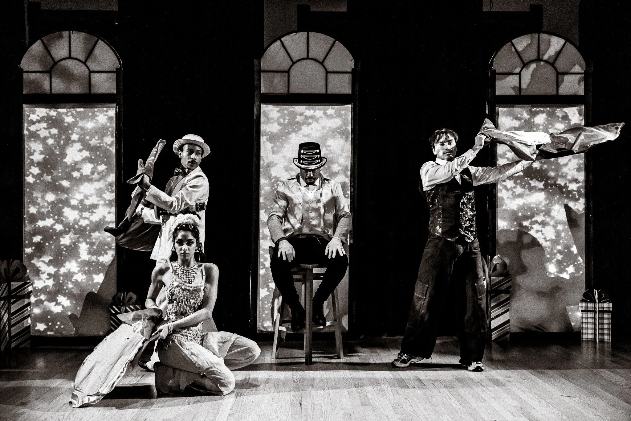 4 performers on stage in vaudeville style costumes, photo is black and white. Click for tickets