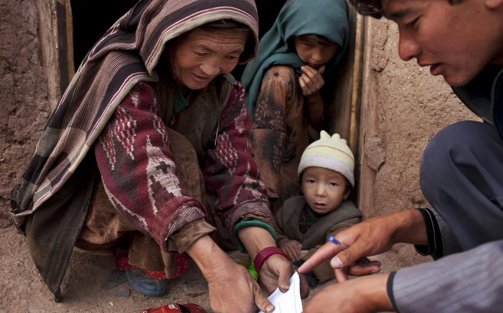 An enumerator collects information from a woman in Afghanistan. Source : UNFPA via Flickr