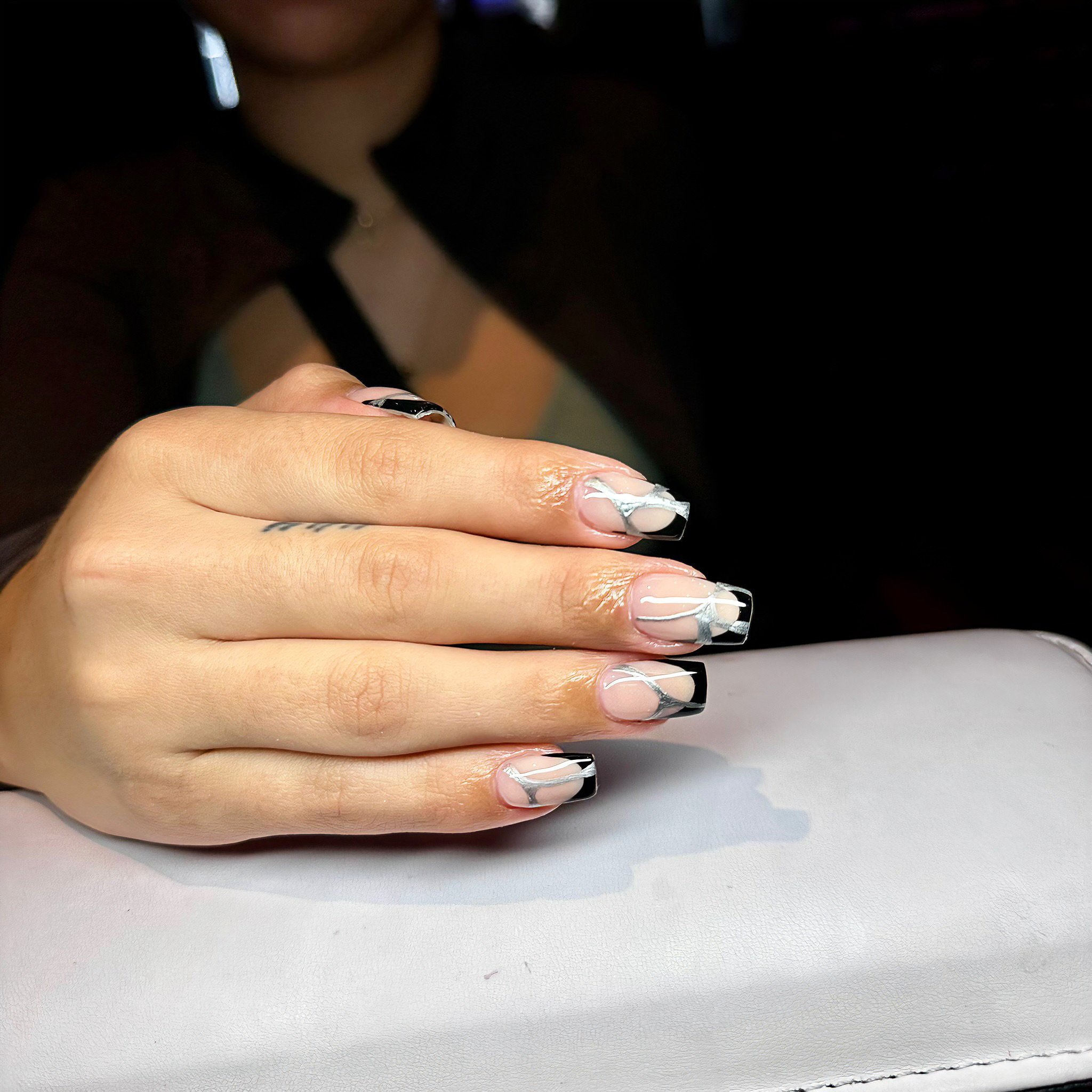 French Tip ✅
Creativity ✅

Elegance with an edge! ⚡💅 Ashley&rsquo;s creative French tip marries sophistication and boldness, featuring sleek black tips accented by shimmering silver lines. Let your nails make a statement at Bliss Nails &amp; Spa. 

