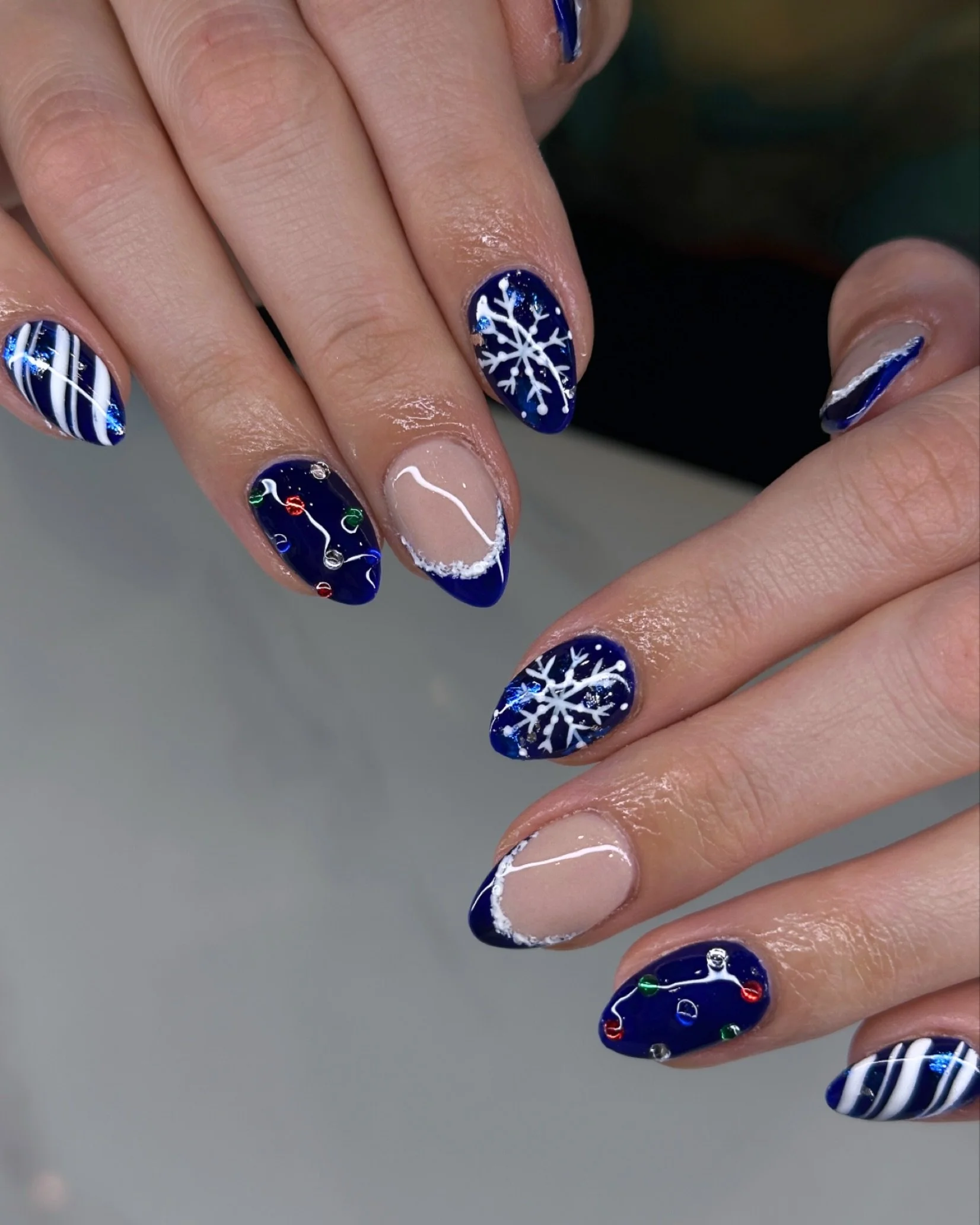 Blue nights, snowy lights, and nails that chill you out ❄️💙
Ashley just dropped this winter‑ready look &mdash; icy tips, snowflakes, candy‑stripe swirls, and holiday lights all in one set. It&rsquo;s cozy + cool for the season.

📍 Boston &bull; Med