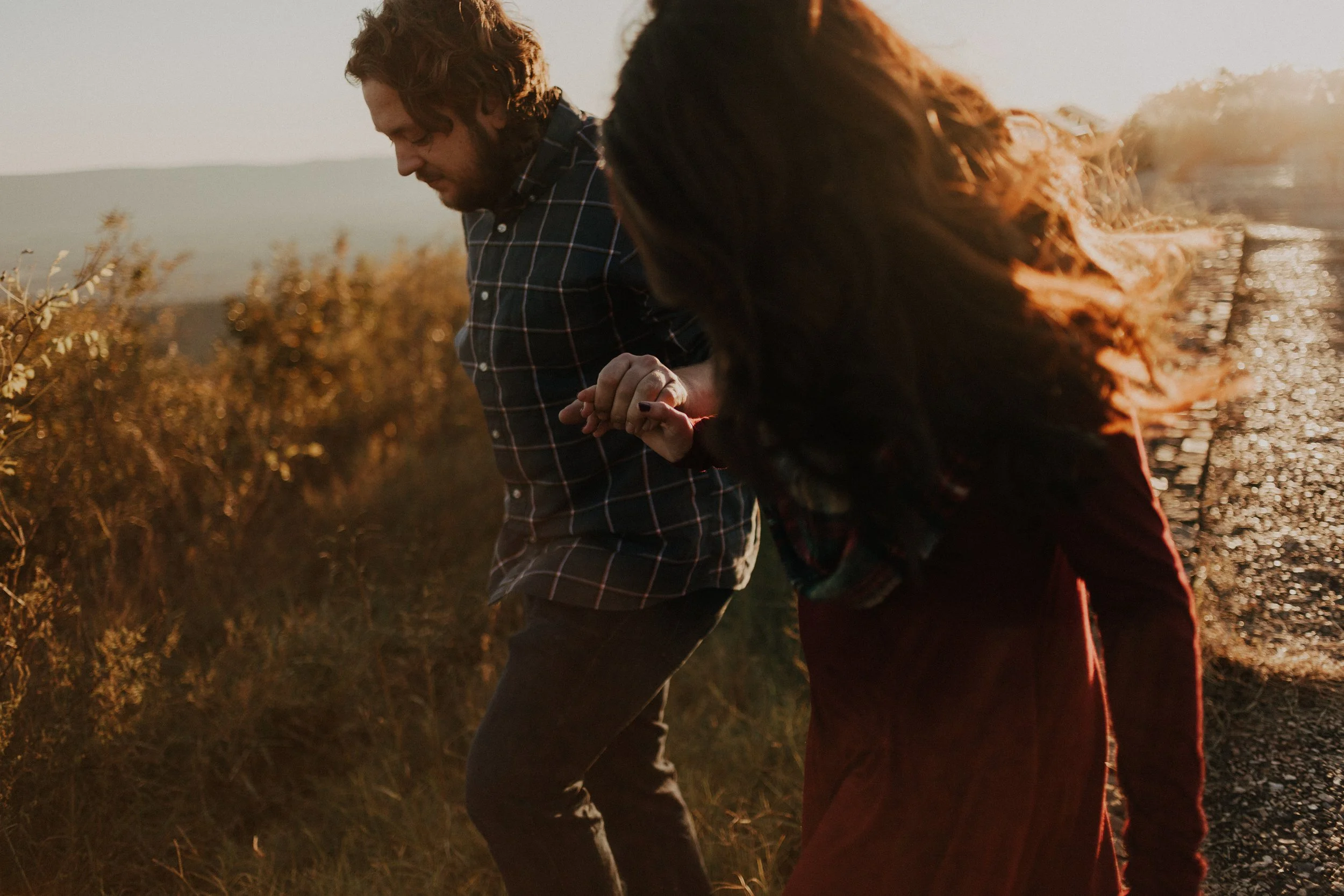 man and woman walking on sunset path