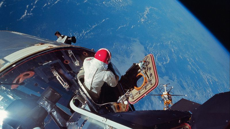 Apollo 9 CM pilot Dave Scott emerges from the hatch, testing some of the spacesuit systems that will be used for lunar operations. The photo was taken from the hatch of the docked LM by Rusty Schweickart in March 1969. (NASA)