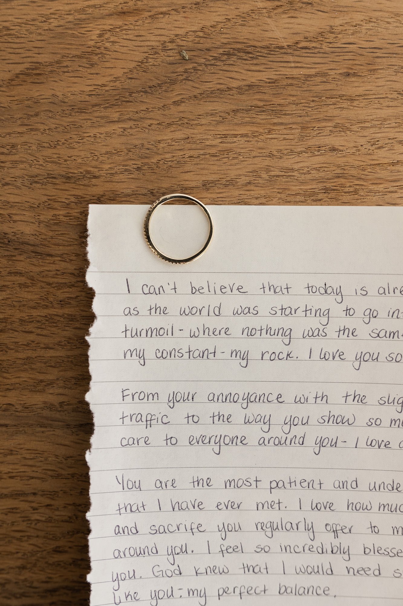 wedding ring on top of a handwritten note on lined paper