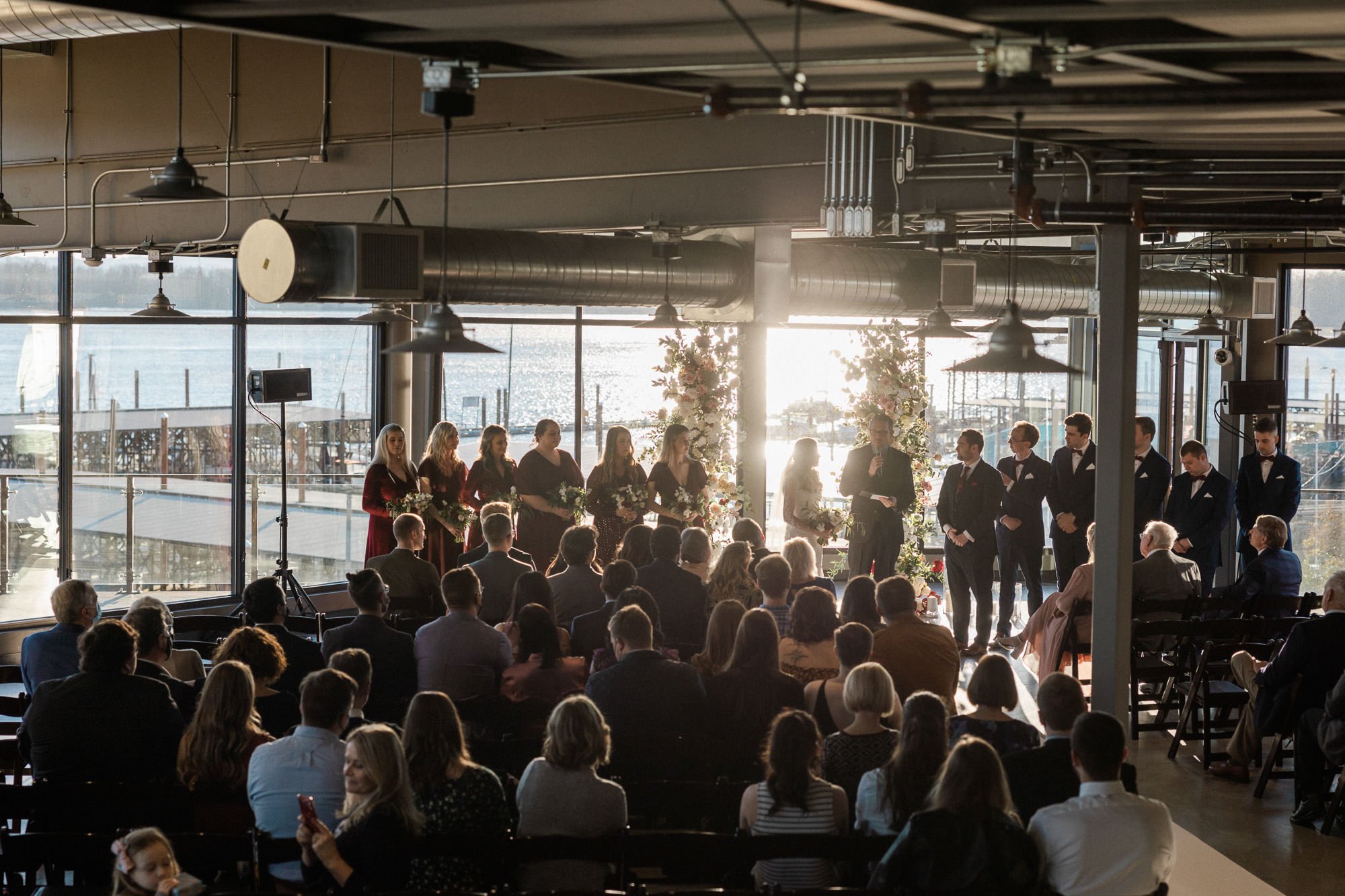 sun beams through large windows during wedding ceremony at black pearl on the columbia