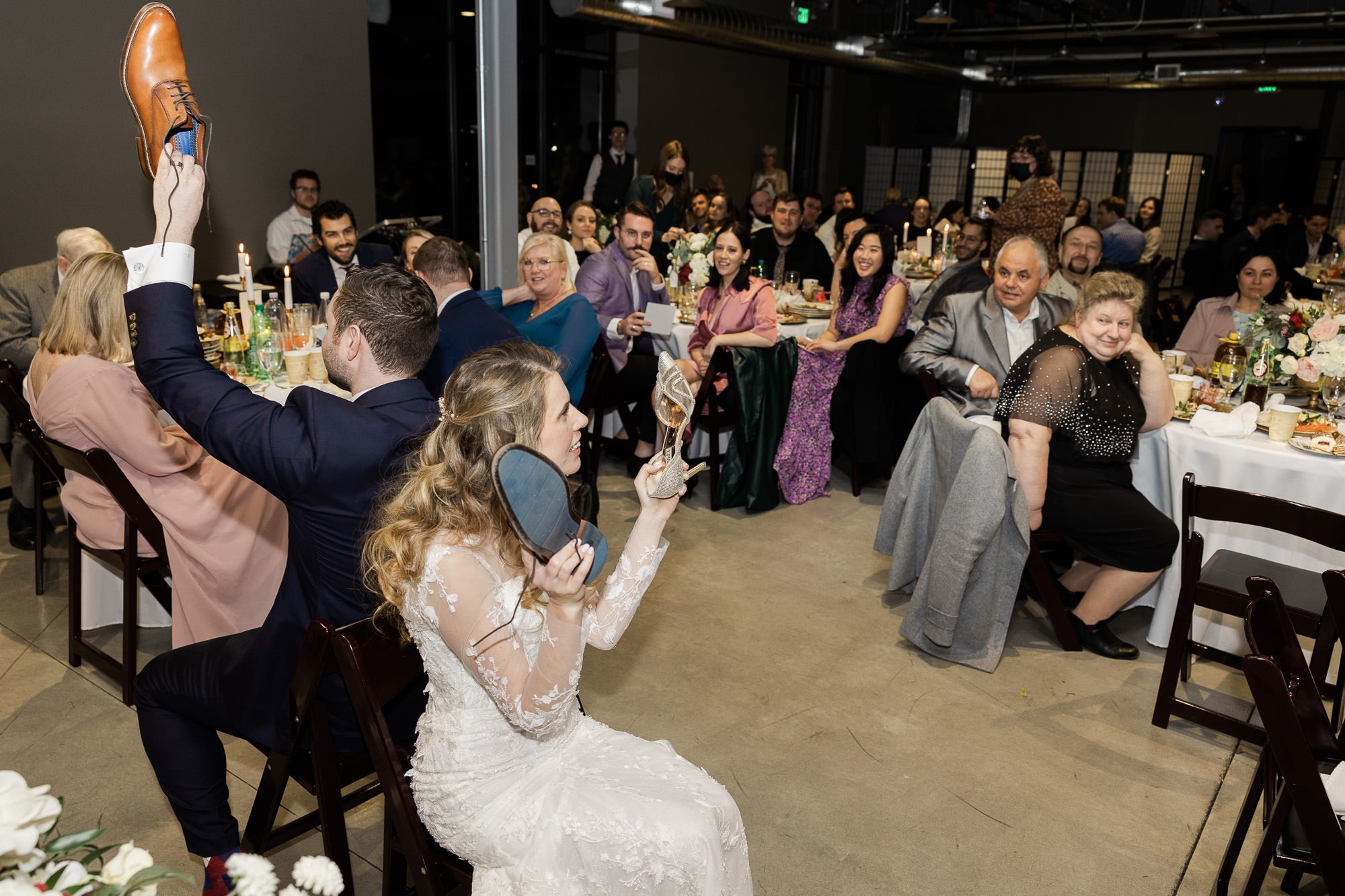 bride and groom play shoe game during wedding reception