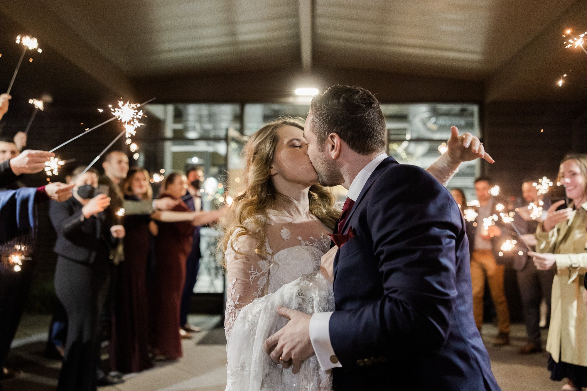 bride and groom kiss during sparkler send off