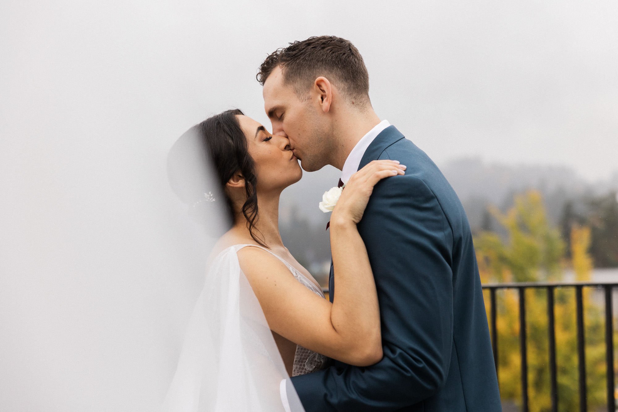 bride and groom kiss on balcony at ironlight wedding venue in lake oswego, oregon