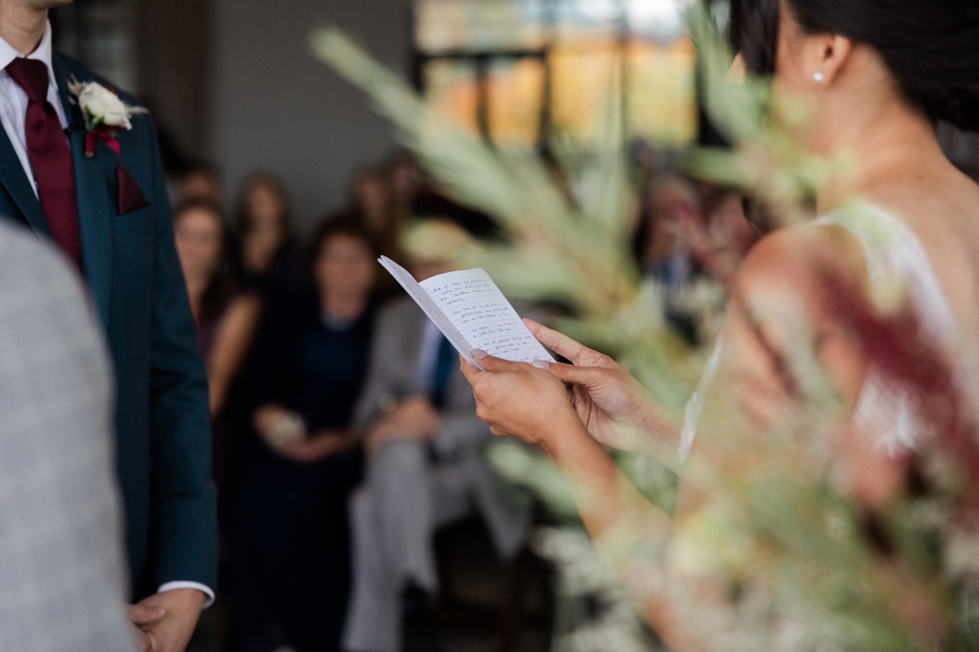 brides hands hold vow book during wedding ceremony at ironlight wedding venue in lake oswego, oregon