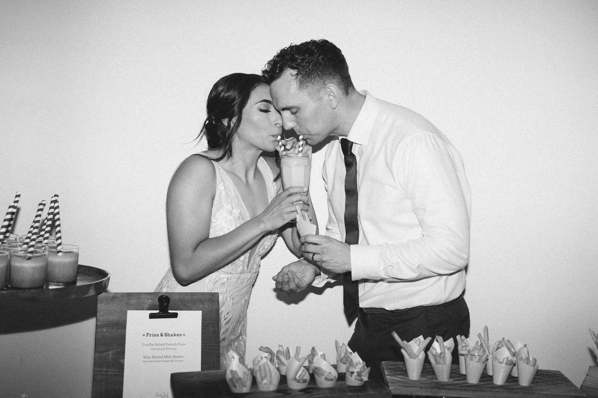 bride and groom share a milkshake during wedding reception at ironlight wedding venue in lake oswego, oregon