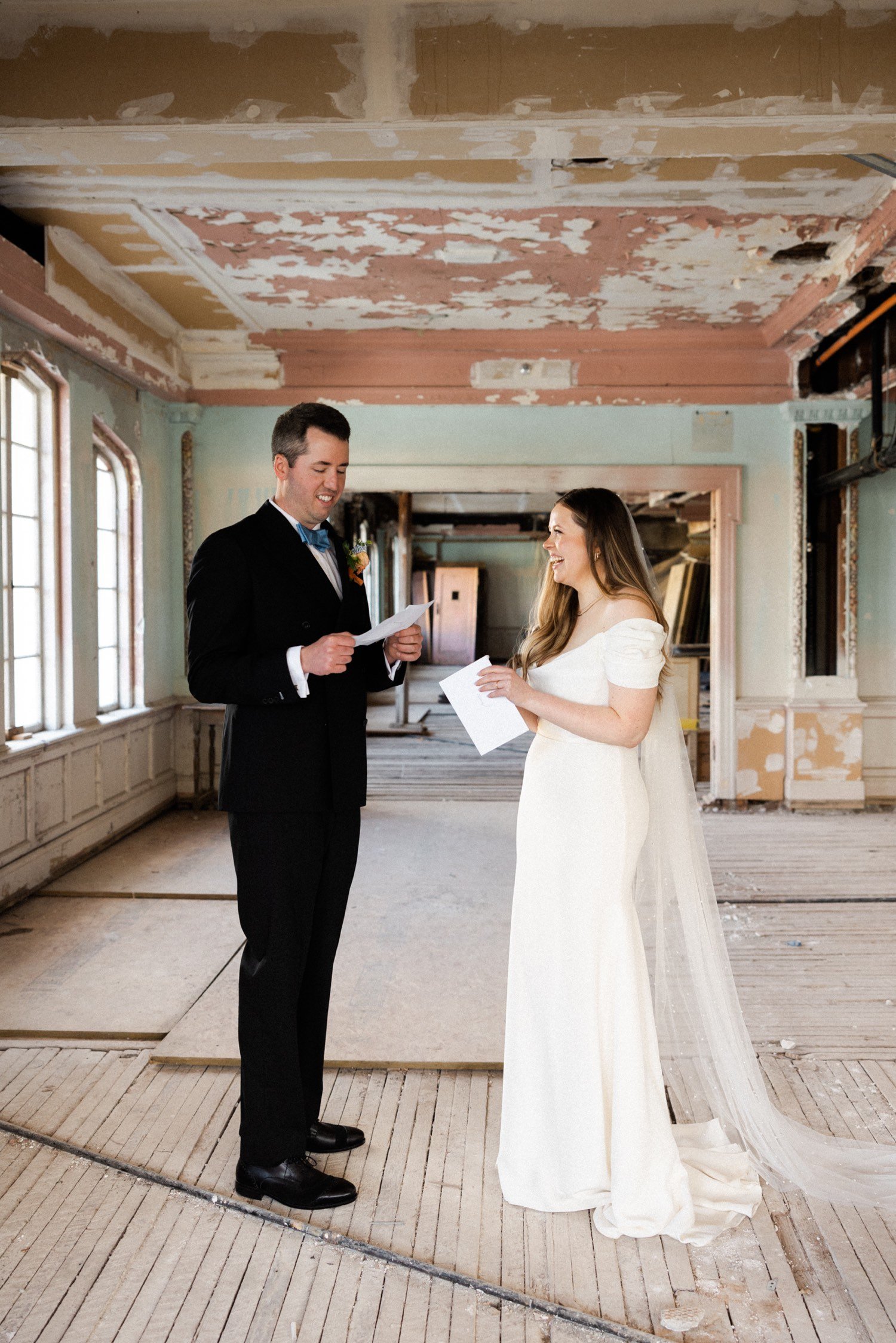 ruins at the astor astoria wedding-31_bride and groom stand next to each other holding cards.jpg