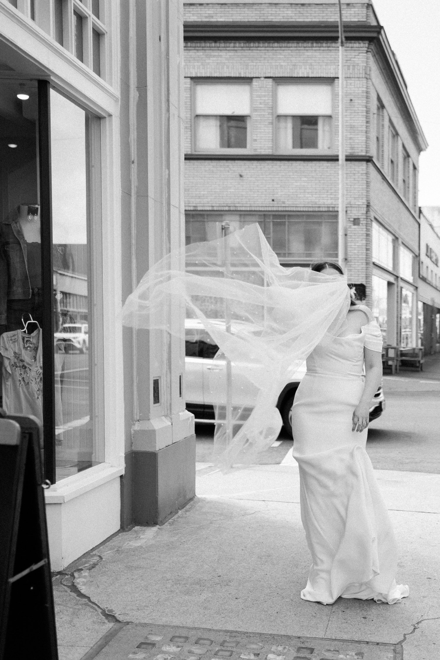 ruins at the astor astoria wedding-44_bride walks down street as veil blows in wind.jpg