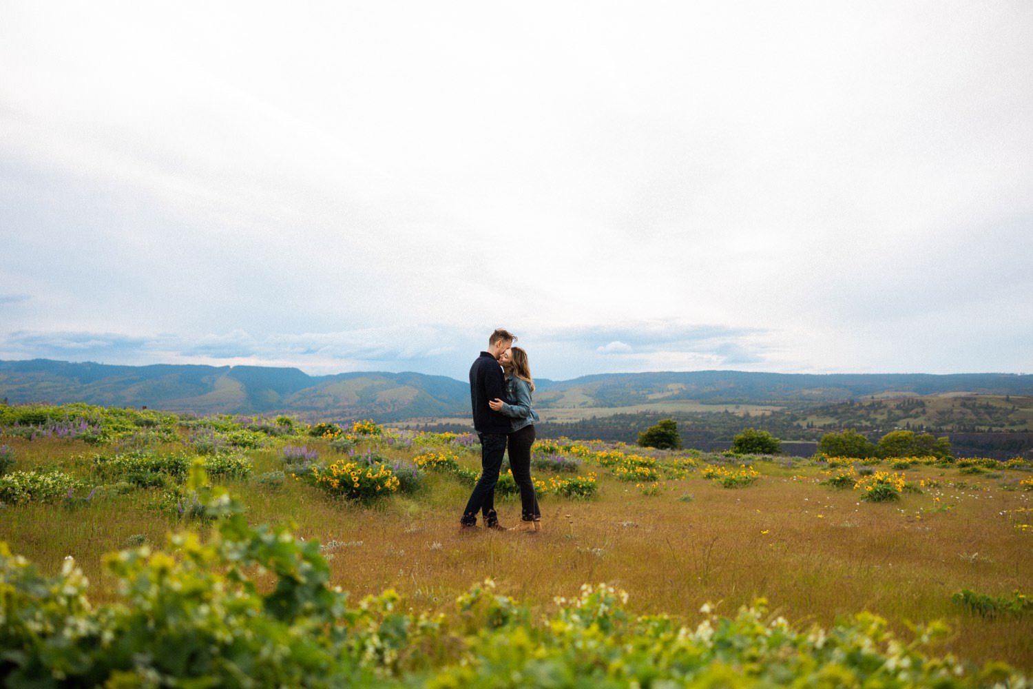 20_Wildflower Engagement Session at Rowena Crest98_man and woman hug each other and kiss during engagement session at rowena crest.jpg