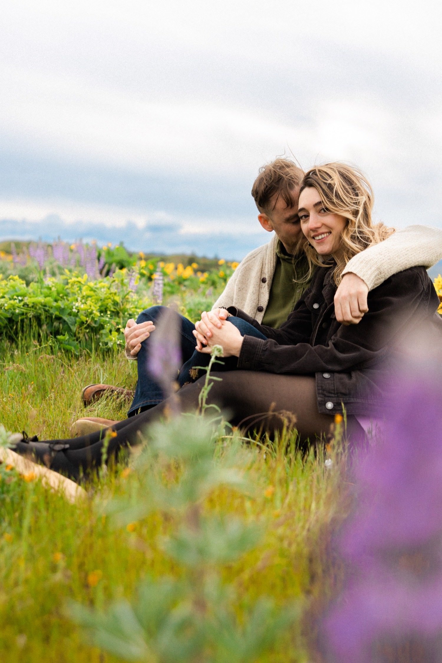 man and woman sit in field of balsamroot and lupine at rowena crest.jpg
