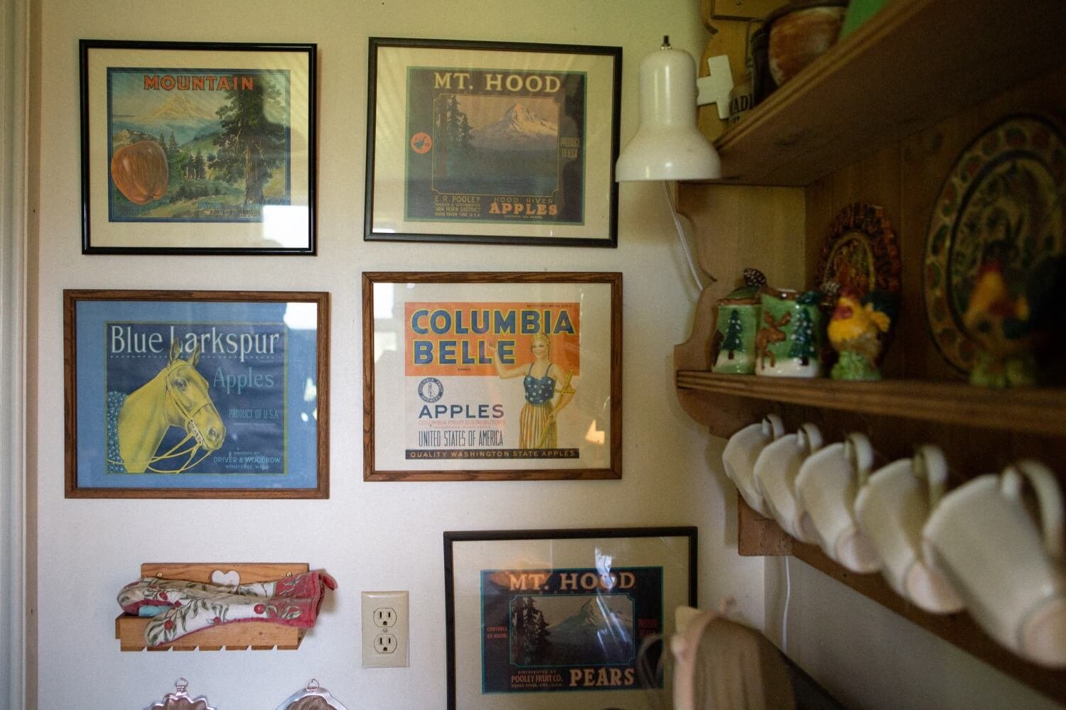 007_Mount Hood Organic Farms Wedding-8954_Five framed prints on wall next to wood shelf holding coffee cups.jpg