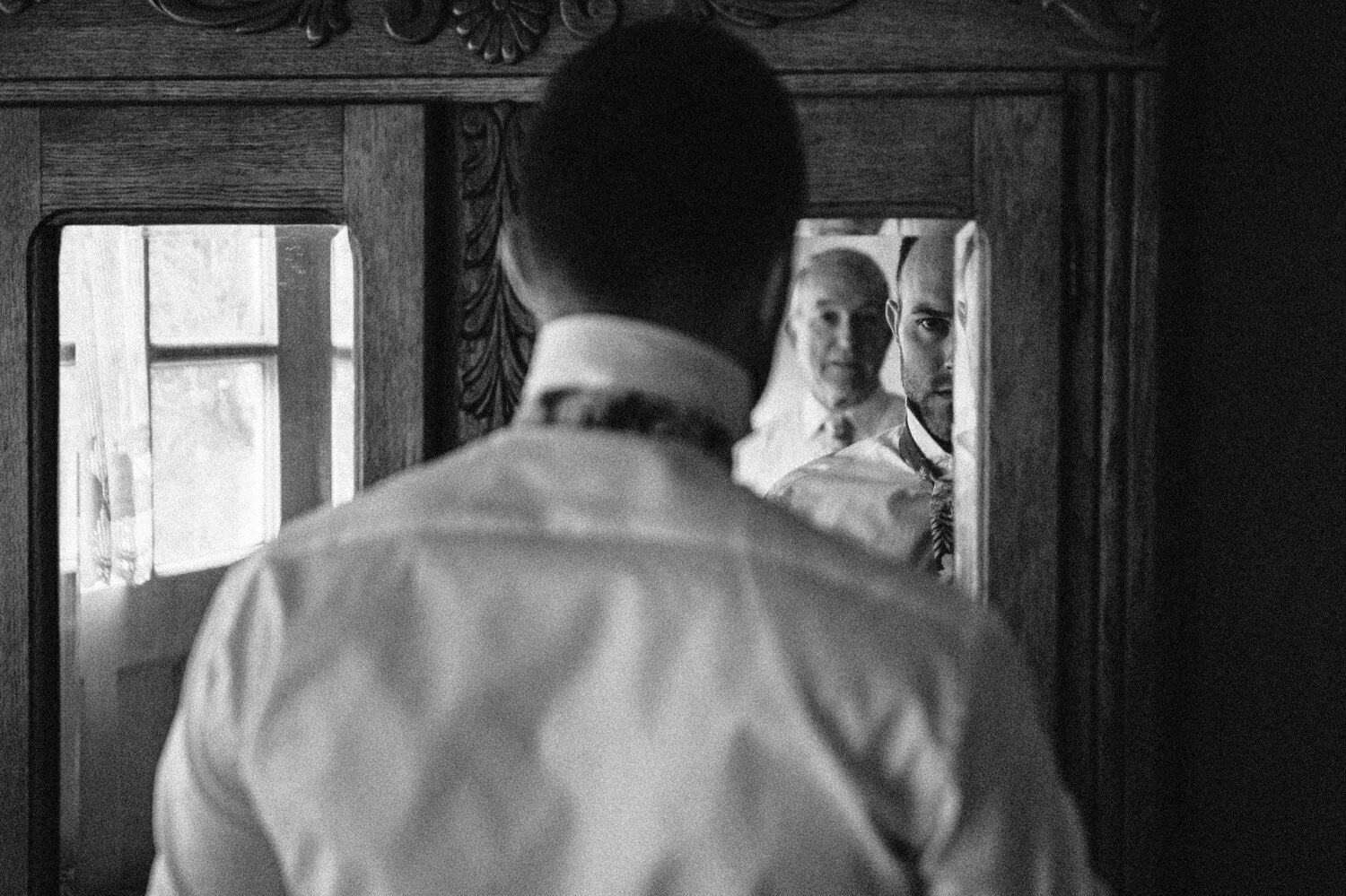 018_Mount Hood Organic Farms Wedding-9112_Two men look in armoire’s mirror while putting on tie.jpg