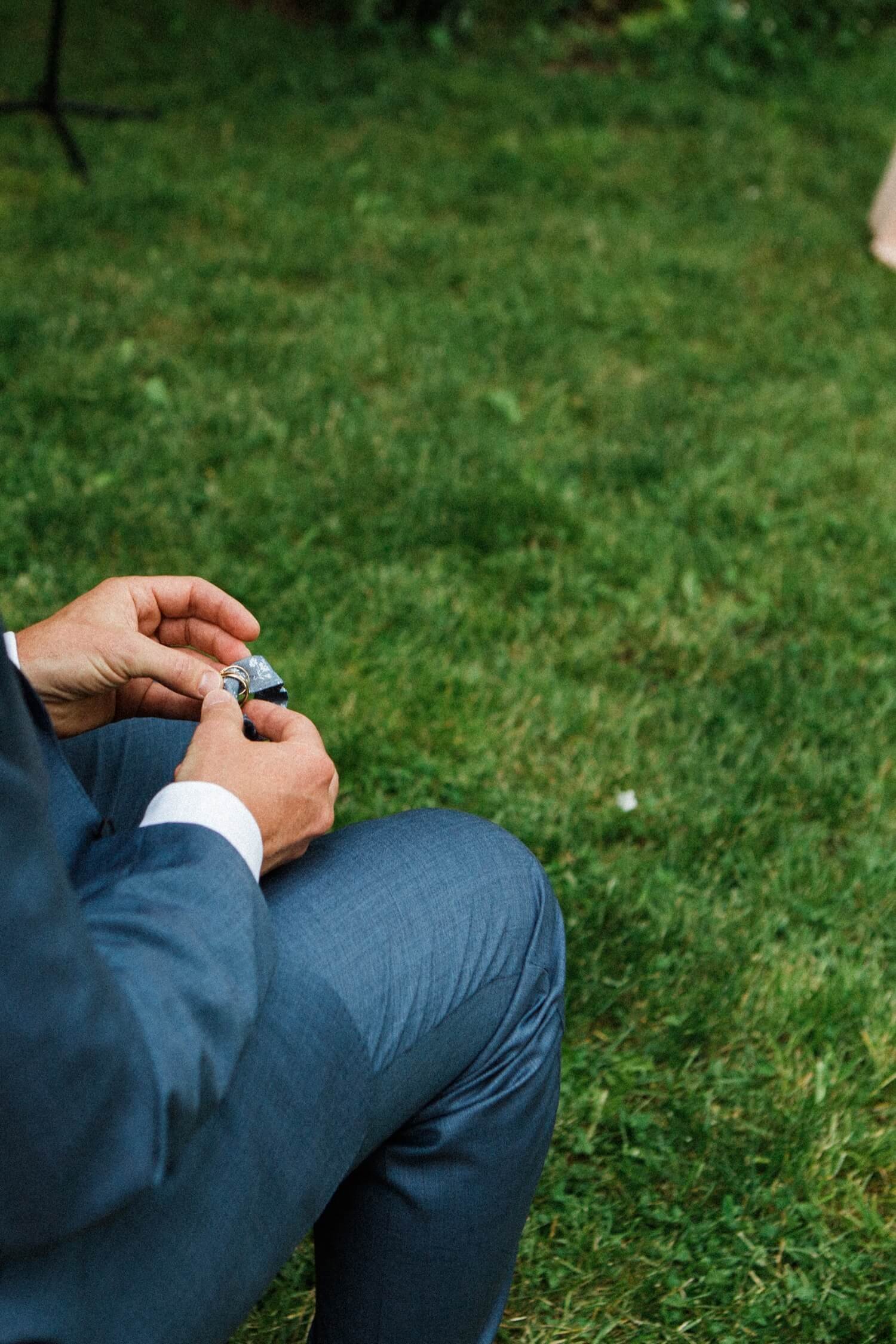 046_Mount Hood Organic Farms Wedding-Man in blue suit holds wedding rings.jpg