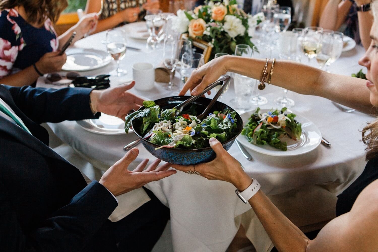 071_Mount Hood Organic Farms Wedding-Man passes bowl of salad to woman.jpg