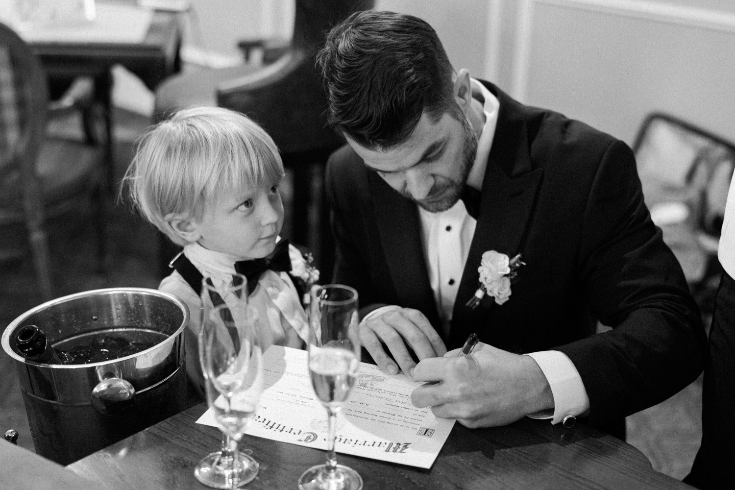  Man signs marriage license while young boy looks at him 