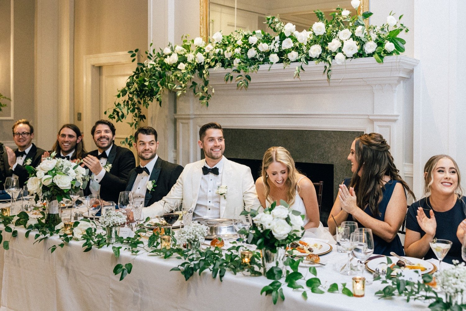  Wedding party laughs while listening to toasts 