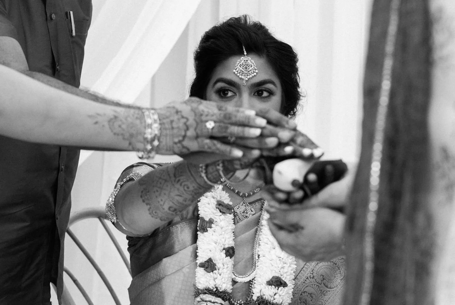 002_Oregon Golf Club Indian Wedding-131_indian holds hand with relatives hands over blessing during wedding ceremony.jpg