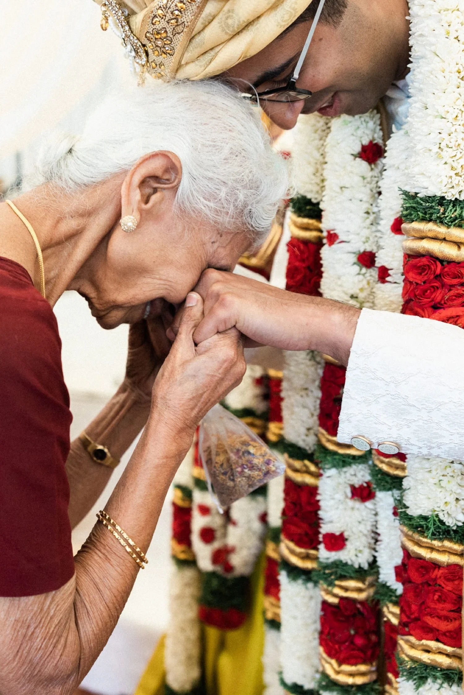 001_Oregon Golf Club Indian Wedding-174_elderly indian woman holds hands of indian groom up to her face.jpg