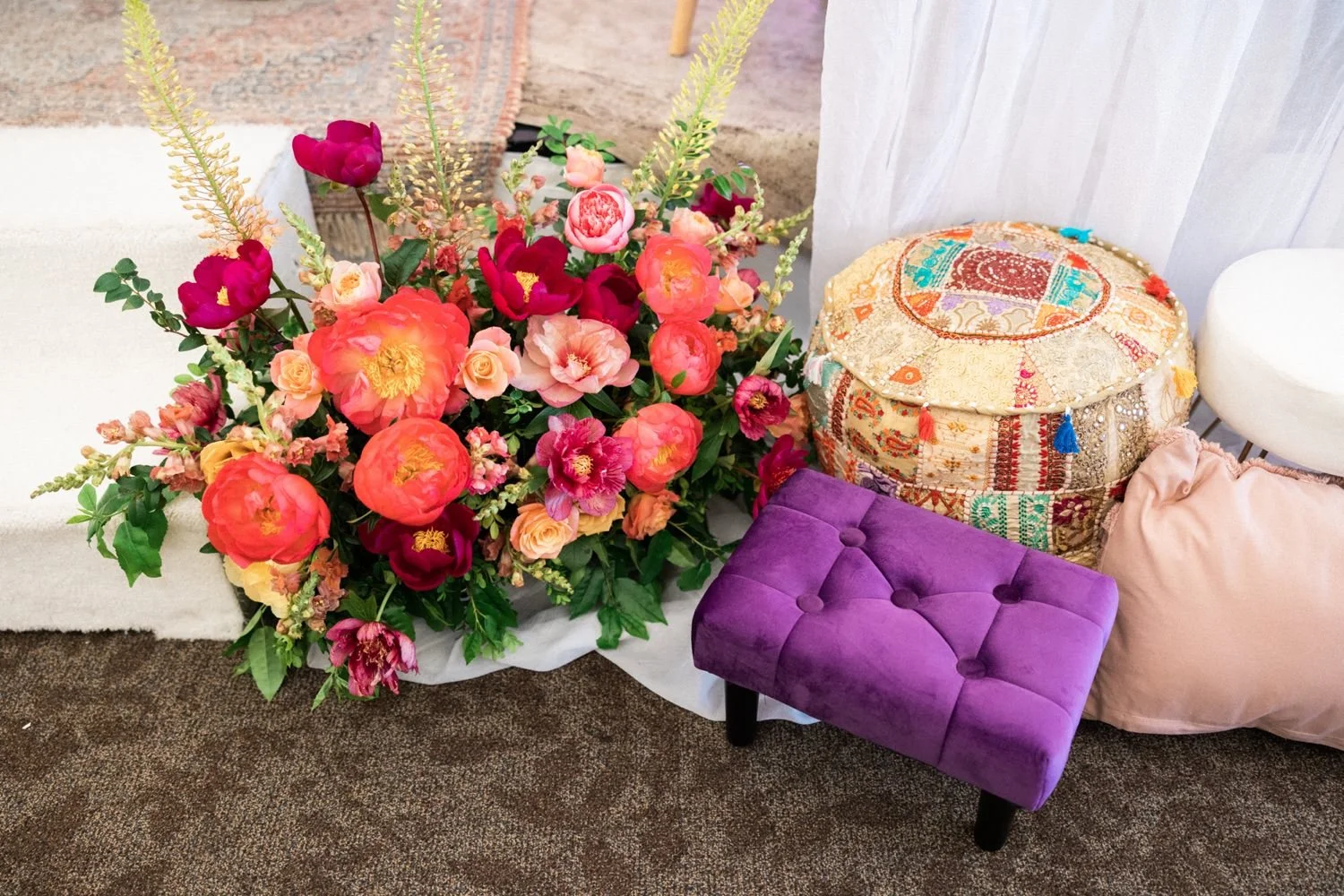 046_Oregon Golf Club Indian Wedding-2_large bouquet of pink and coral florals sit next to colorful ottoman and purple footstool.jpg