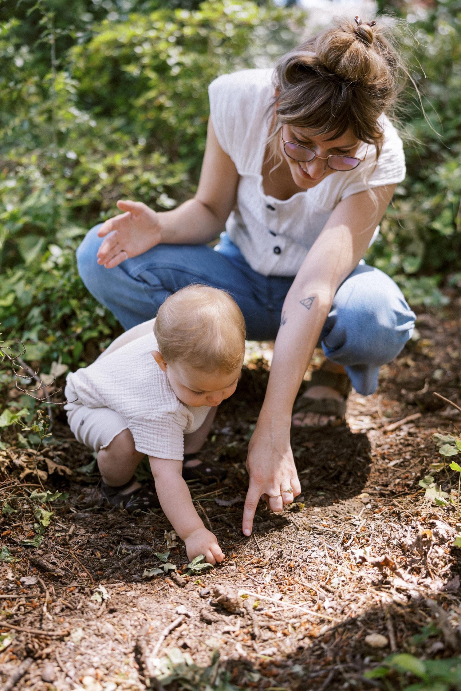 08_Portland Family Photographer-7328_mom points to bug in dirt while squatting next to baby daughter.jpg