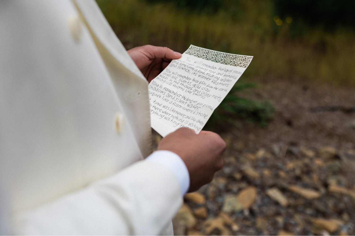 012_The Orchard Hood River Wedding42_man in white suit holds handwritten note.jpg