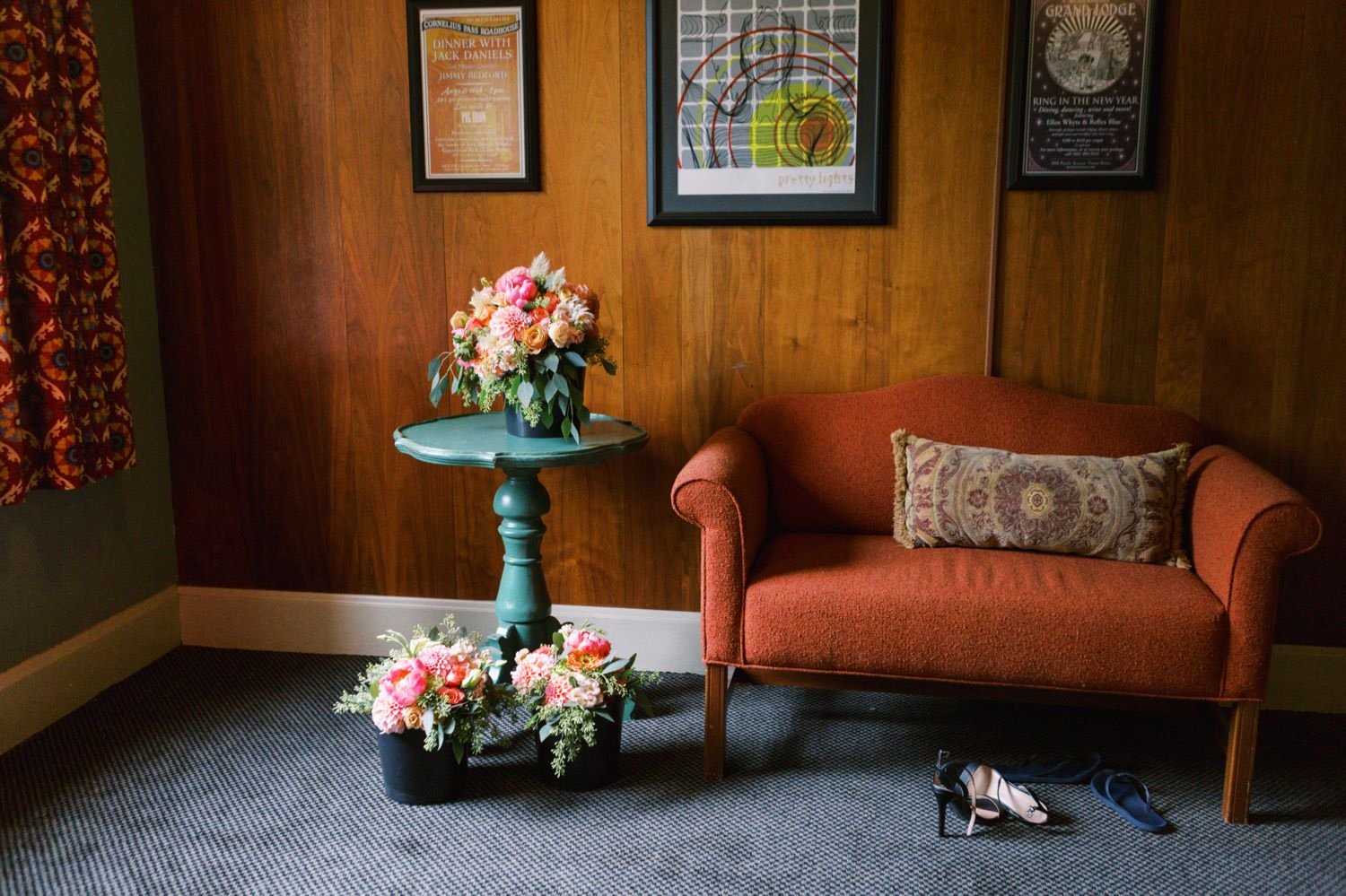  bouquets of flowers sit on green table next to orange couch 