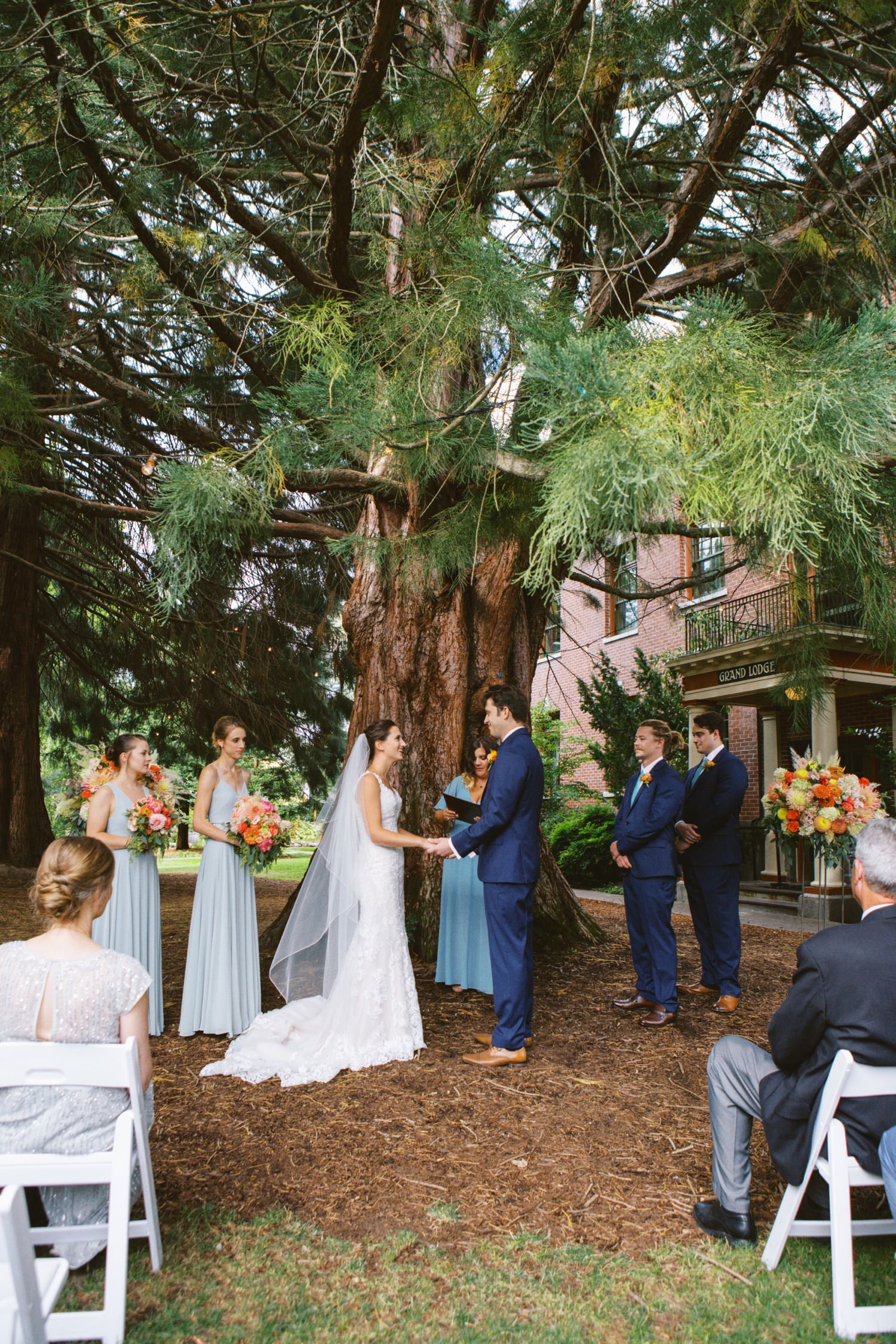  bride and groom and two bridesmaids and two groomsmen stand in front of sequoia at mcmenamins grand lodge during wedding ceremony 