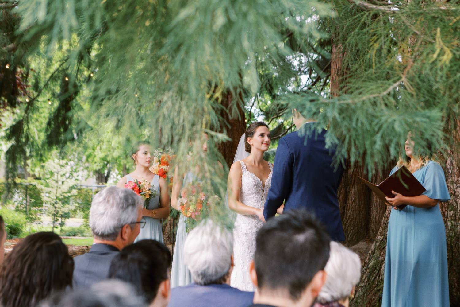  bride looks at groom during wedding ceremony under giant sequoia at mcmenamins grand lodge 