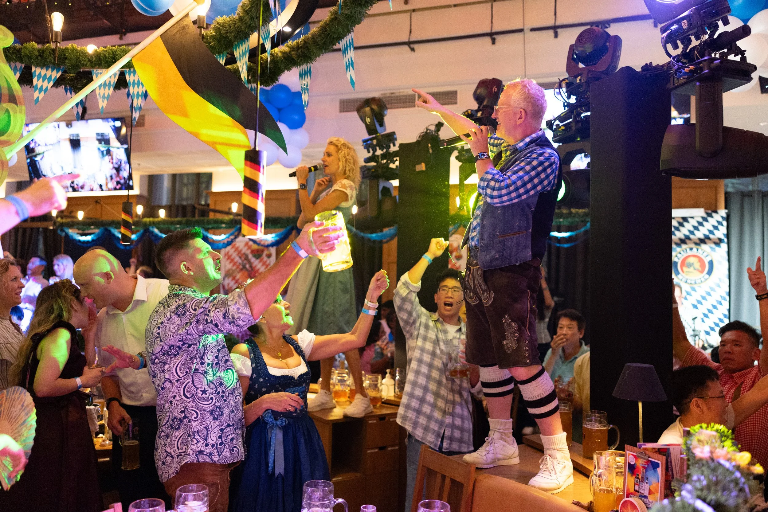  Live band performers Joe and Seine Schürzenjäger singing on tabletop during Oktoberfest Singapore 
