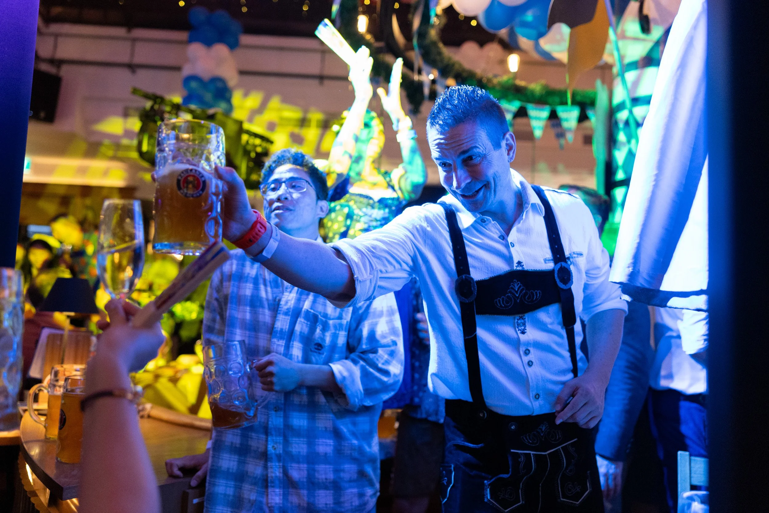  Candid close-up of guests clinking beer mugs during live Oktoberfest celebrations 