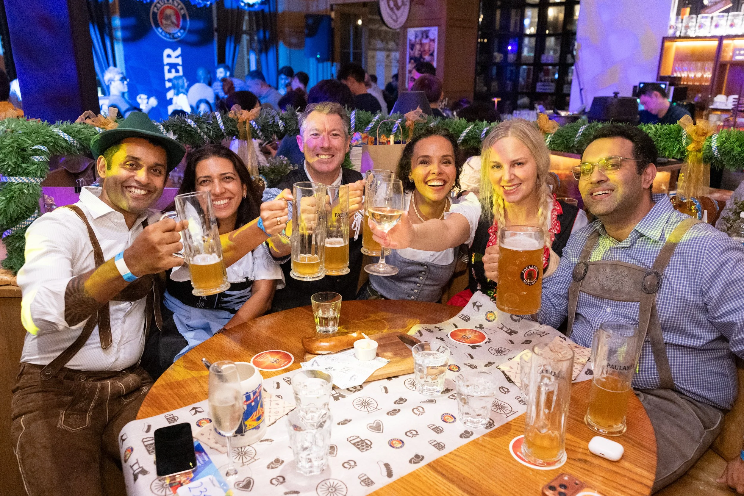  Posed group portrait of attendees raising beer glasses at Paulaner Bräuhaus Singapore 