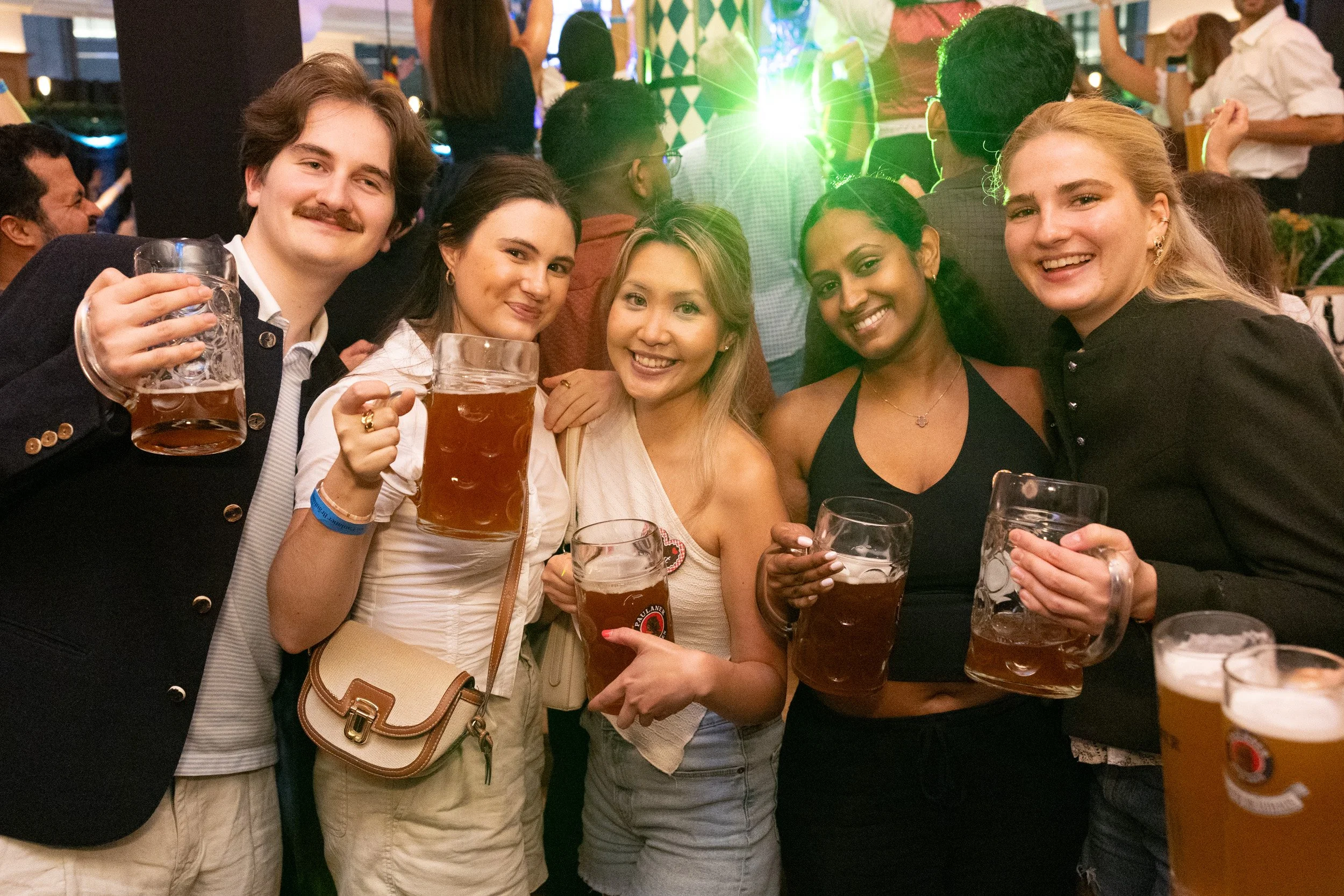  Corporate group posing and toasting at Paulaner Bräuhaus Oktoberfest celebration 