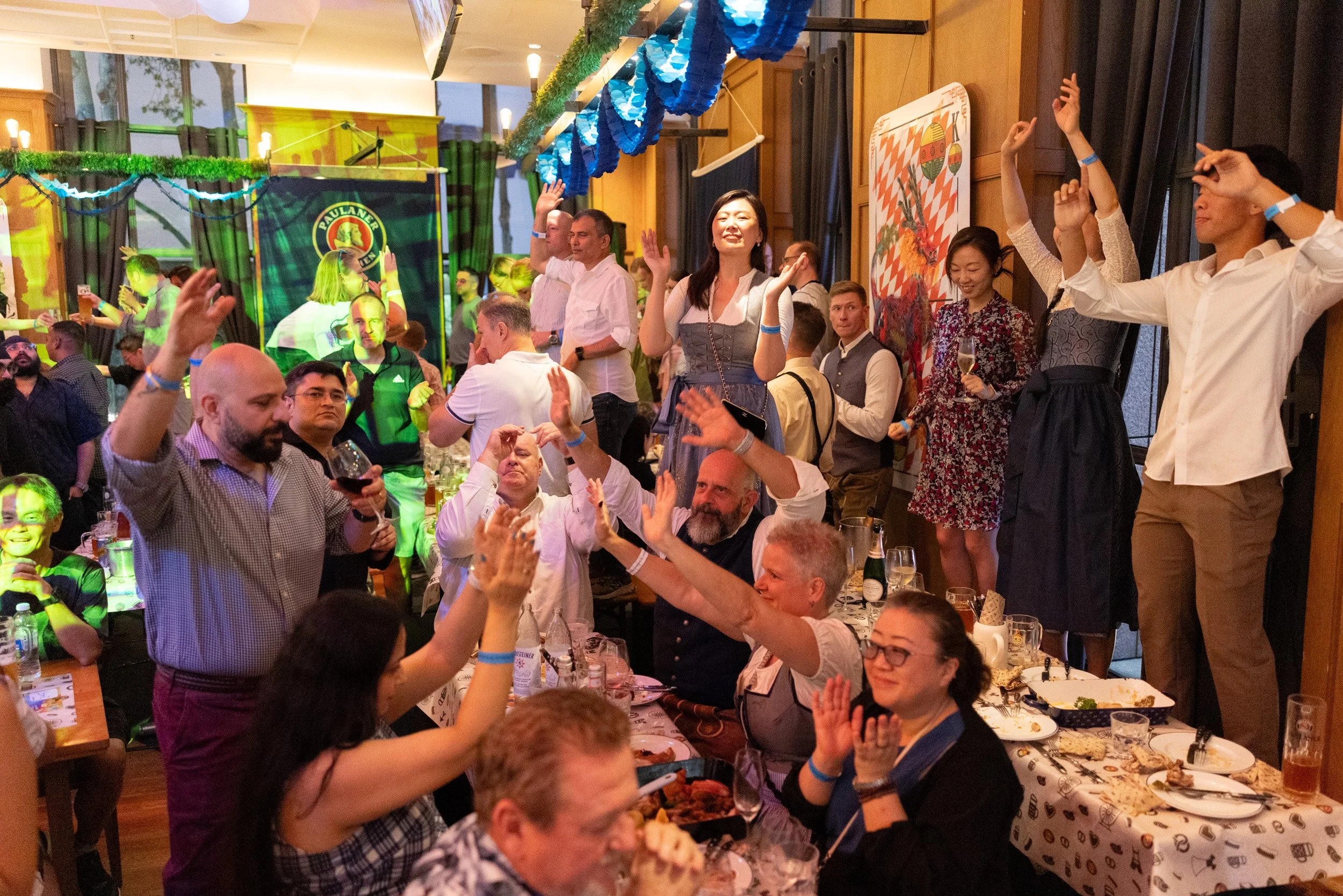  Candid event photography of guests dancing on benches and celebrating at Oktoberfest 