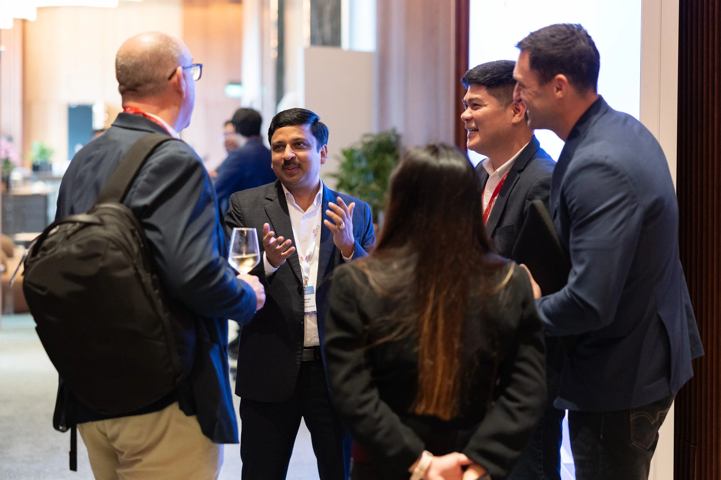  Business professionals engaged in discussion during a corporate event networking break. 