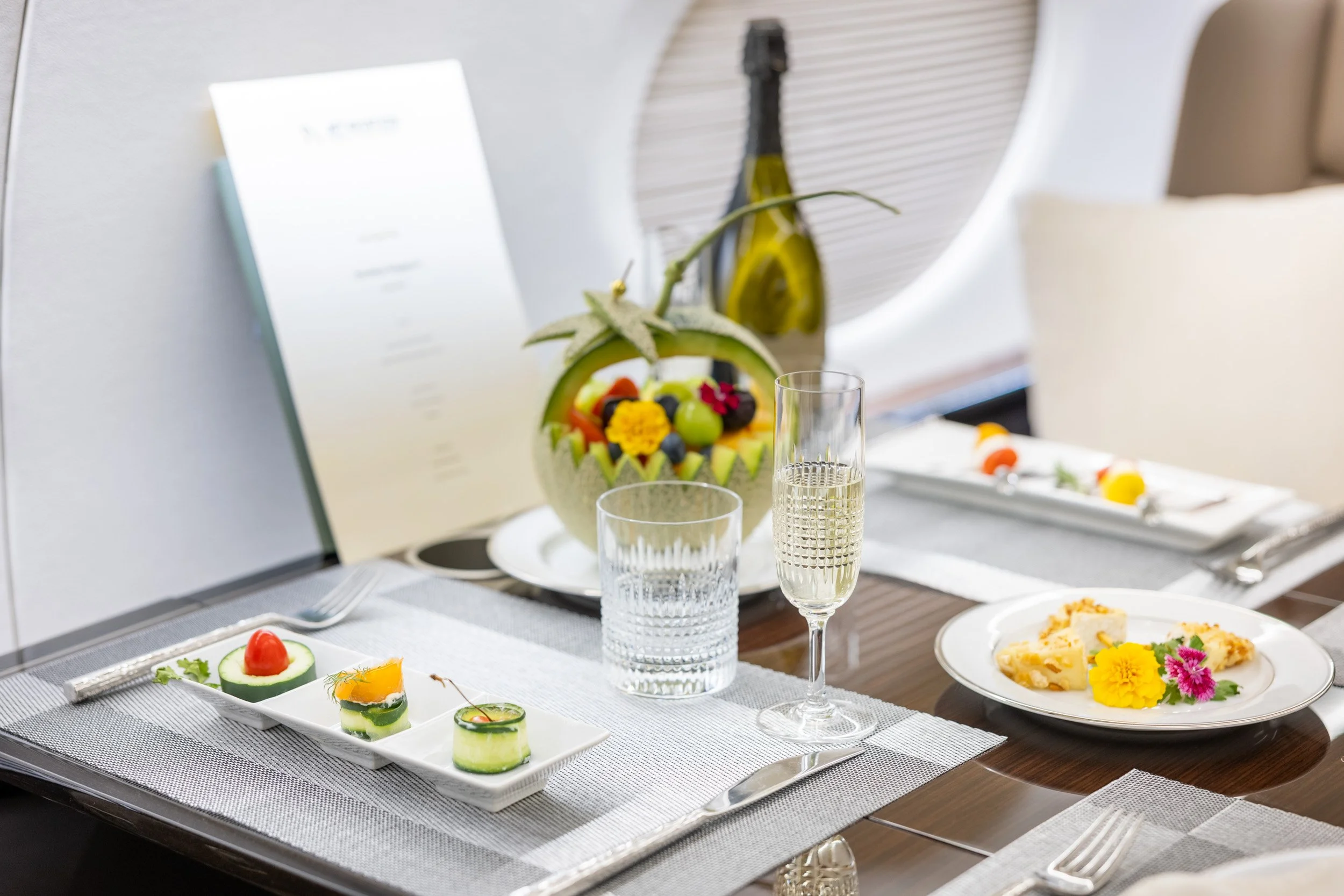  Close up view of gourmet inflight dining service with wine and local pastries. 