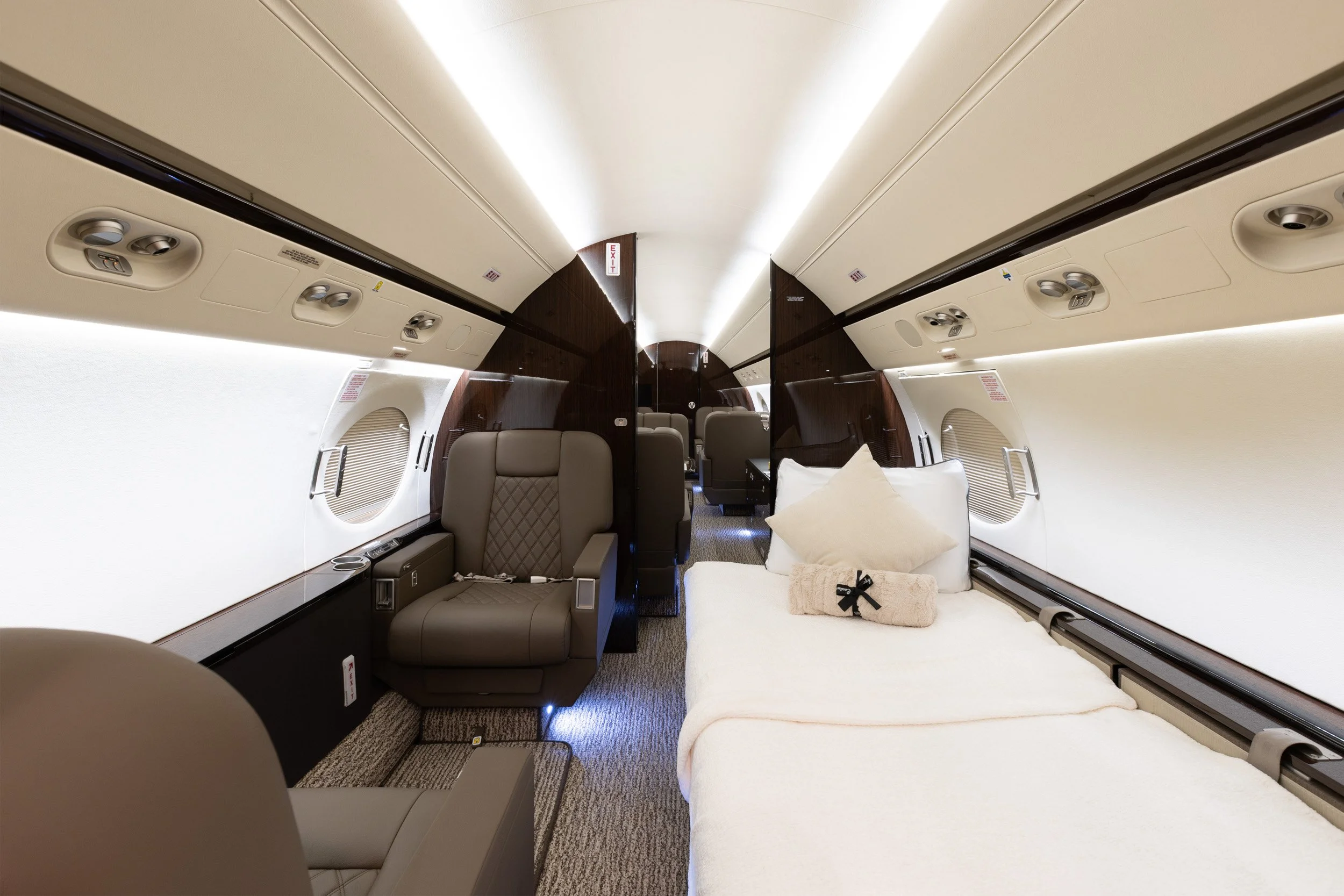  Private jet cabin interior showcasing a convertible bed setup and executive passenger seating. 