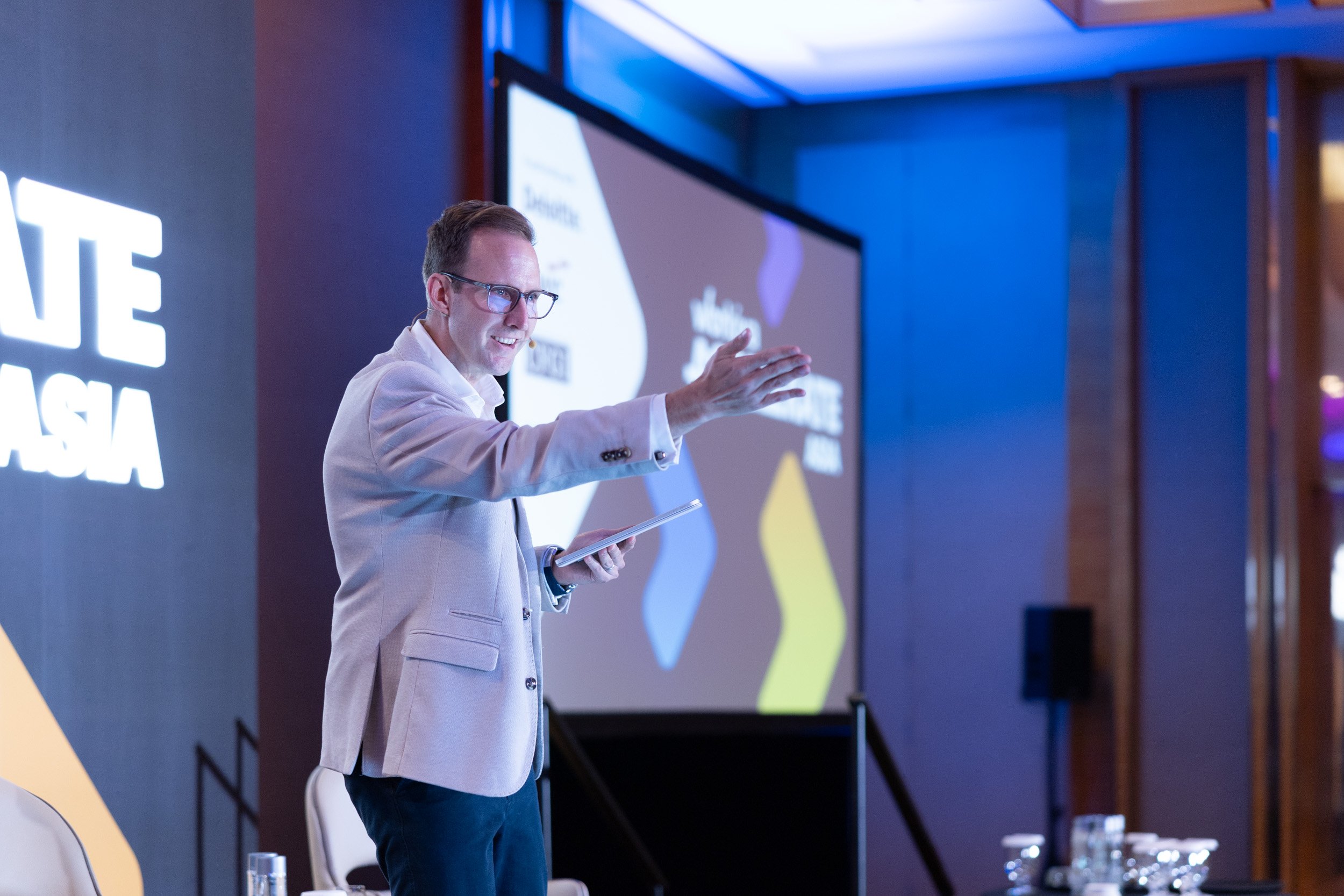  Event host Jackson Burnie addressing attendees on stage at Marina Bay Sands. 