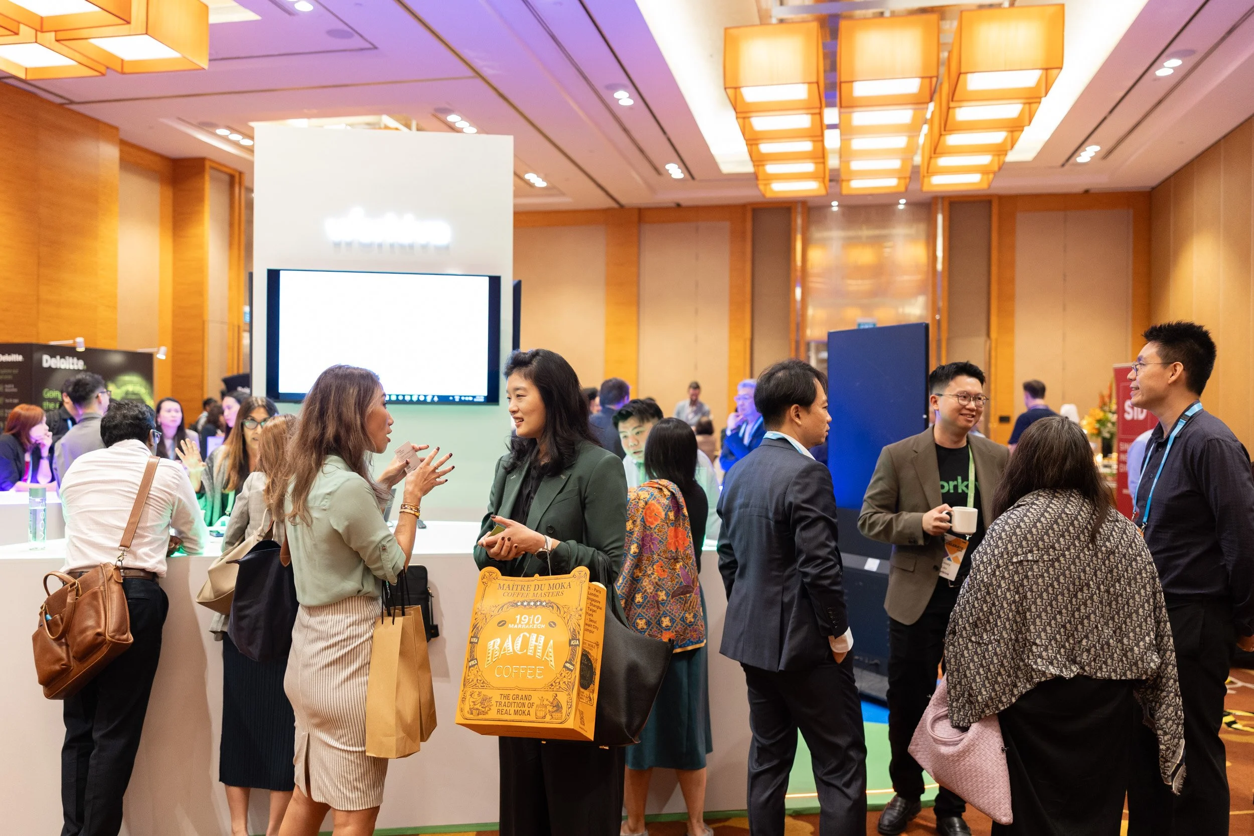  Corporate attendees networking in the exhibition hall in front of the Workiva booth. 