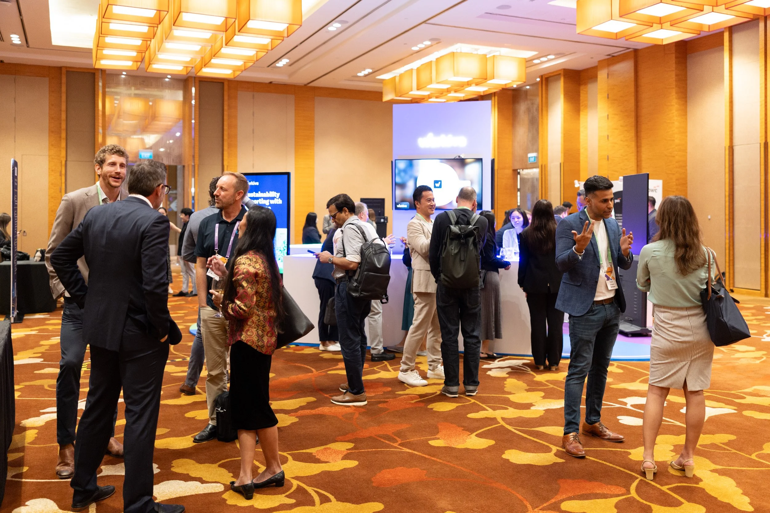  Wide angle view of event attendees networking in the Heliconia Junior Ballroom exhibition foyer. 