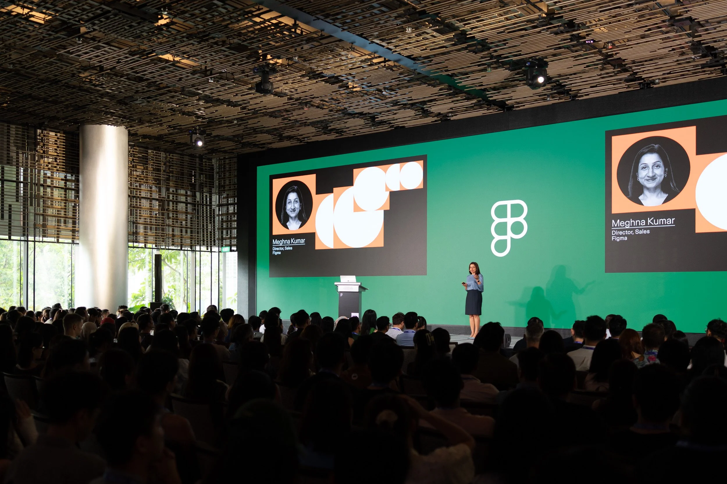  Wide angle stage shot of speaker Meghna Kumar addressing the conference audience. 