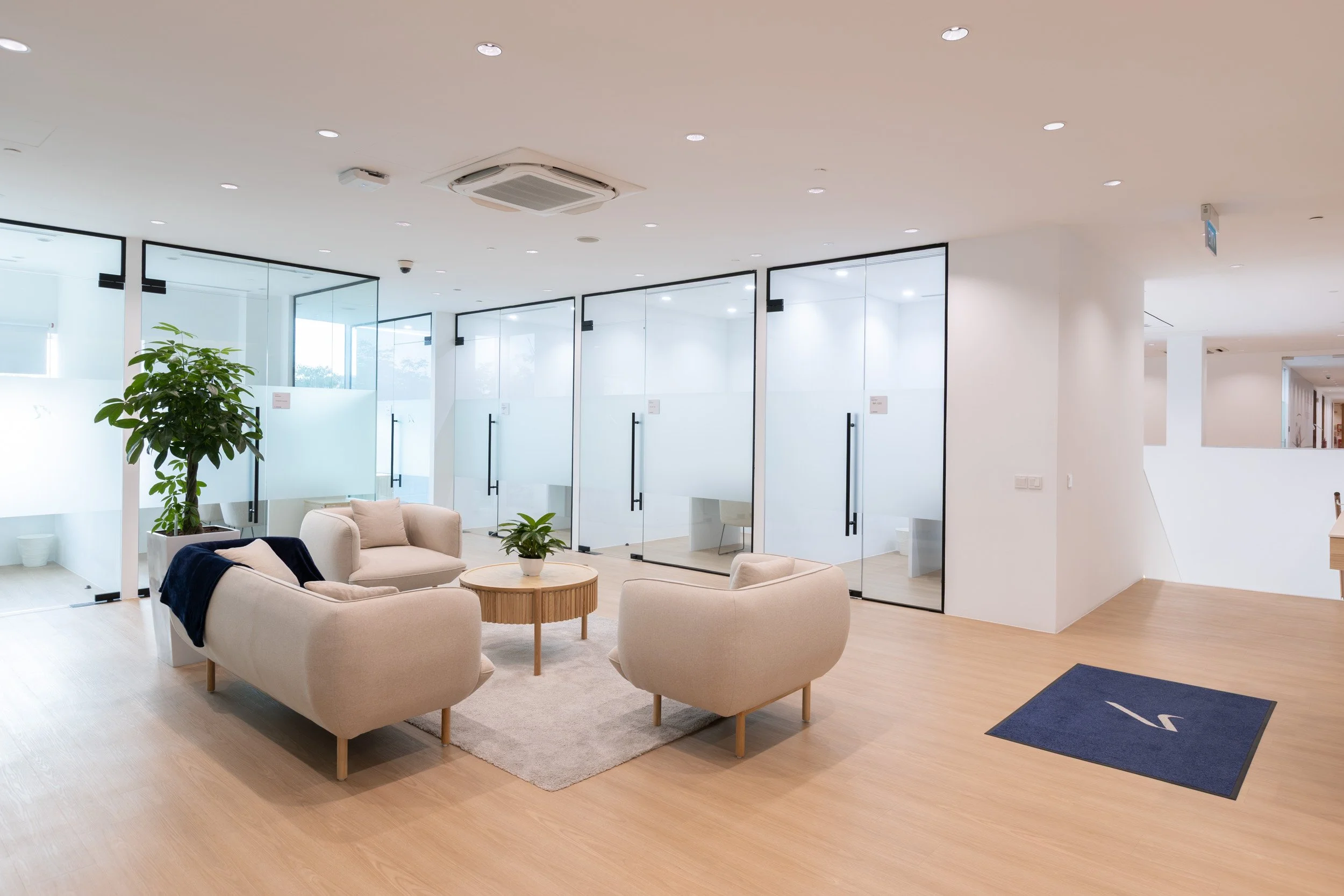  Interior design photography of Jet Aviation customer lounge area showing modern sofas and glass meeting rooms. 