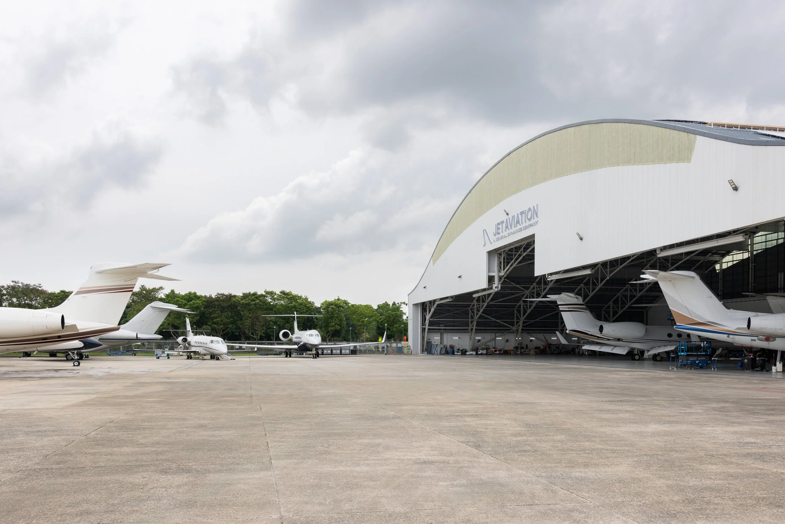 Wide angle exterior shot of Jet Aviation airfield apron and hangar housing private corporate aircraft. 