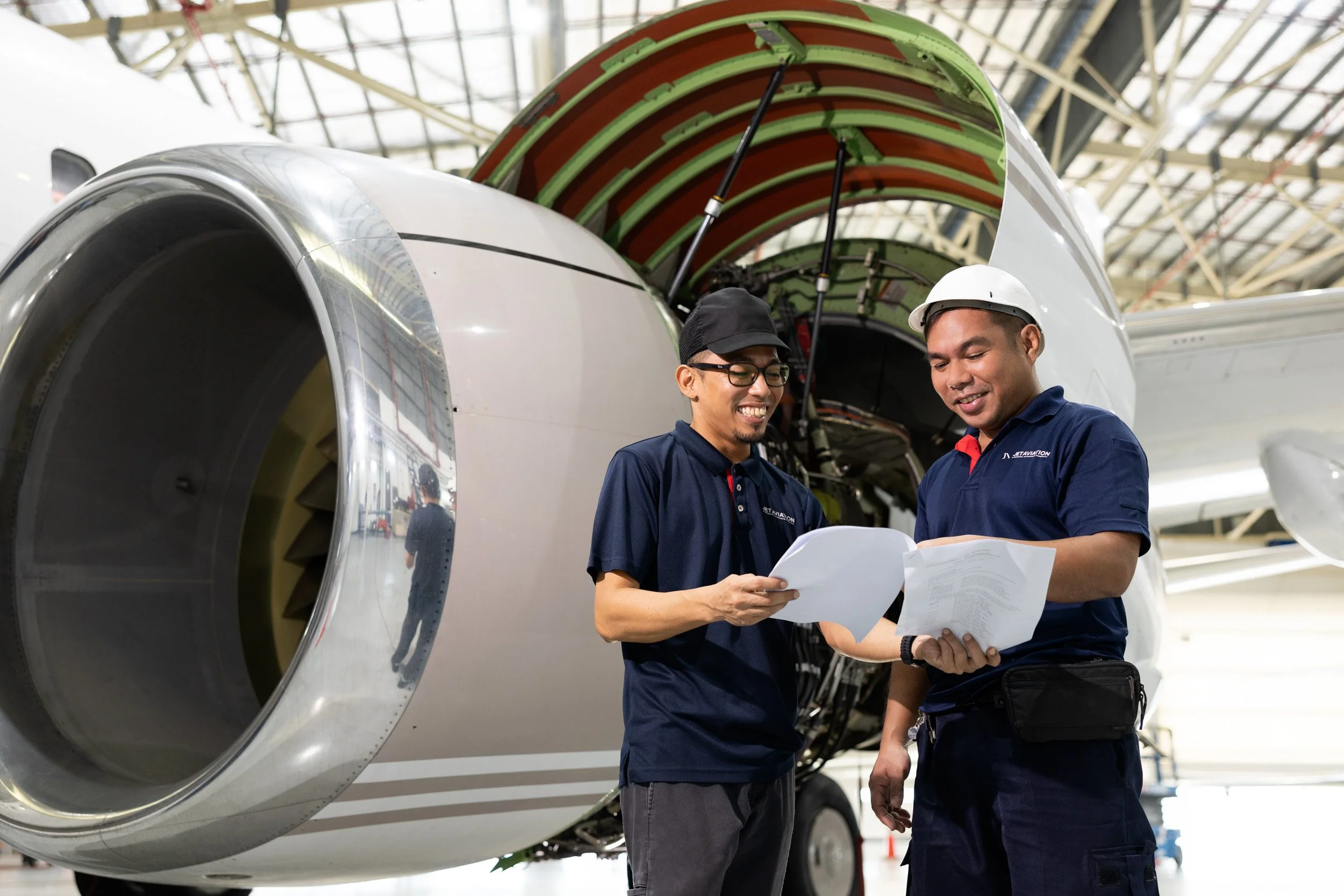  Two Jet Aviation engineers inspecting aircraft engine components during maintenance operations. 