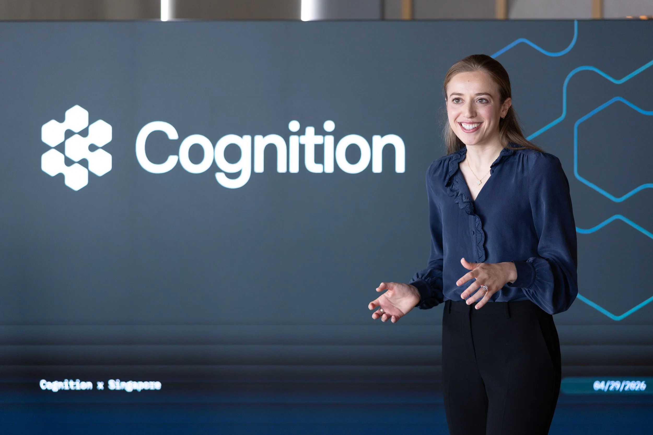  Close-up photograph of Emily Cohen speaking on stage during the Cognition media session. 