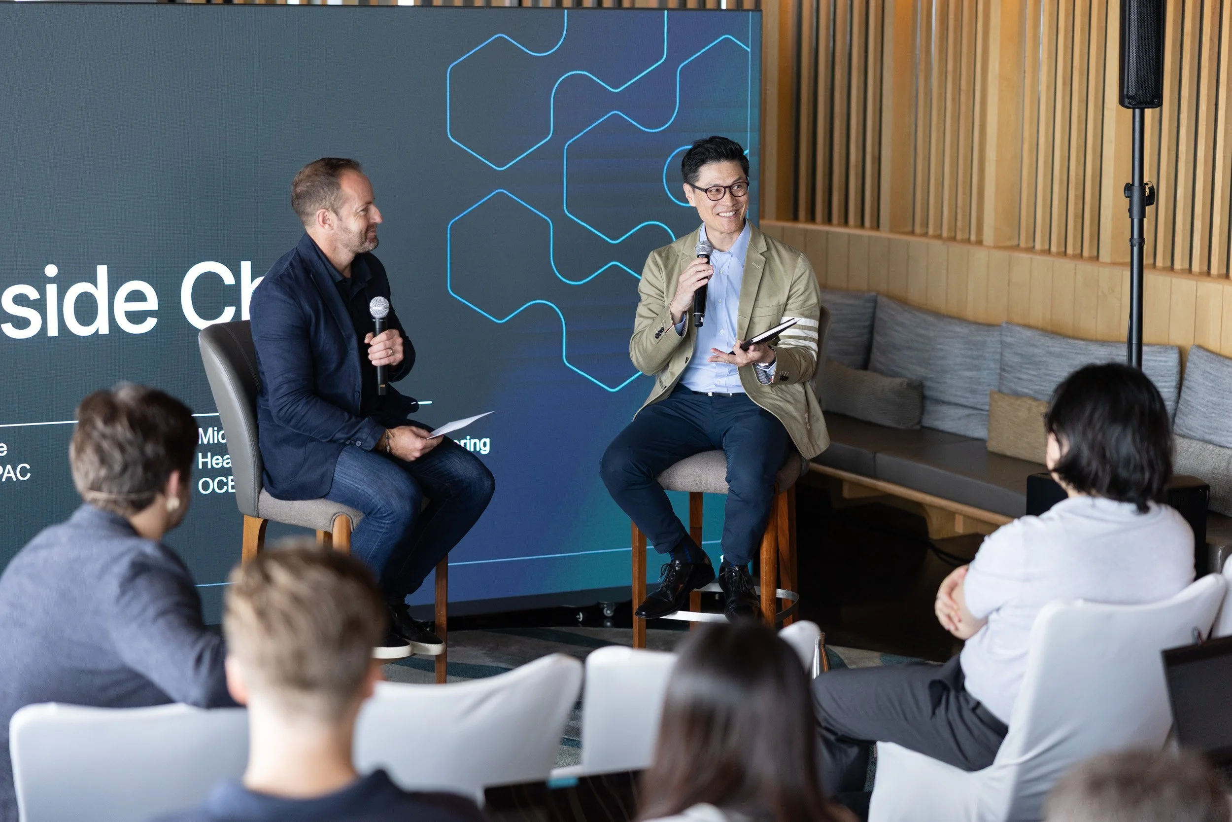  Michael Chung and Richard Spence delivering a product experience presentation on stage. 
