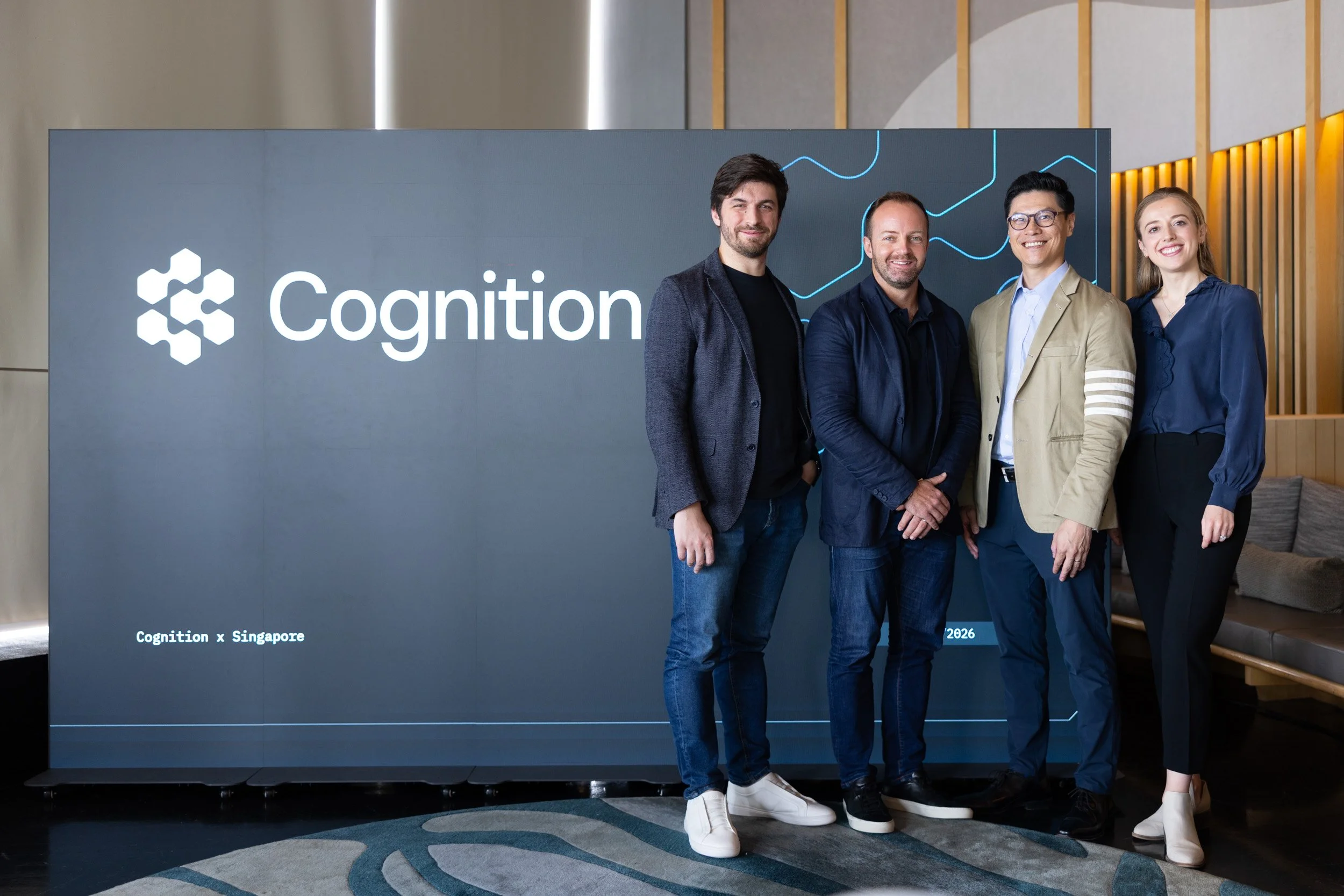  Group portrait of all four Cognition event speakers posed in front of the digital backdrop screen. 
