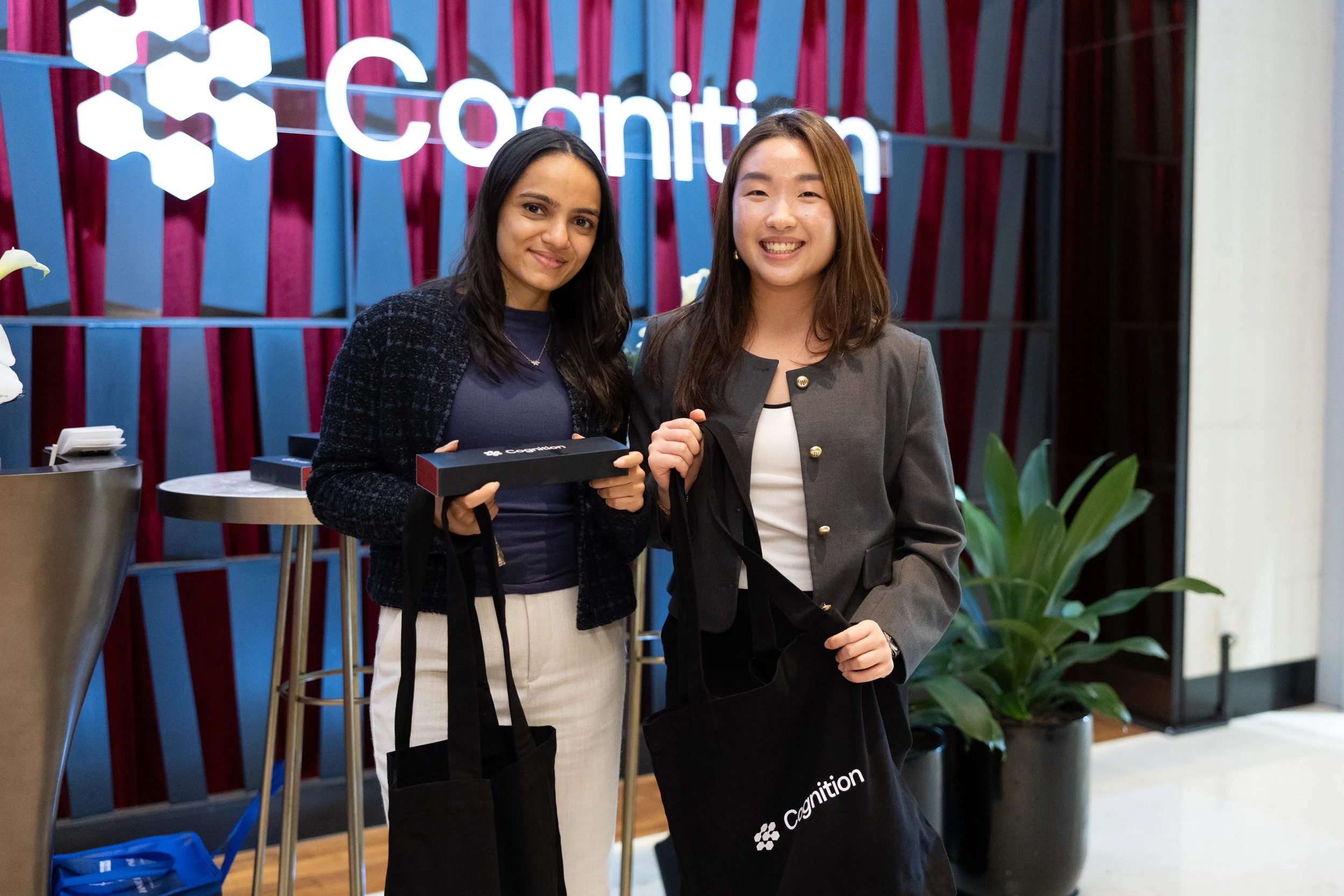  Two guests holding official Cognition event gift bags during the VIP evening reception. 